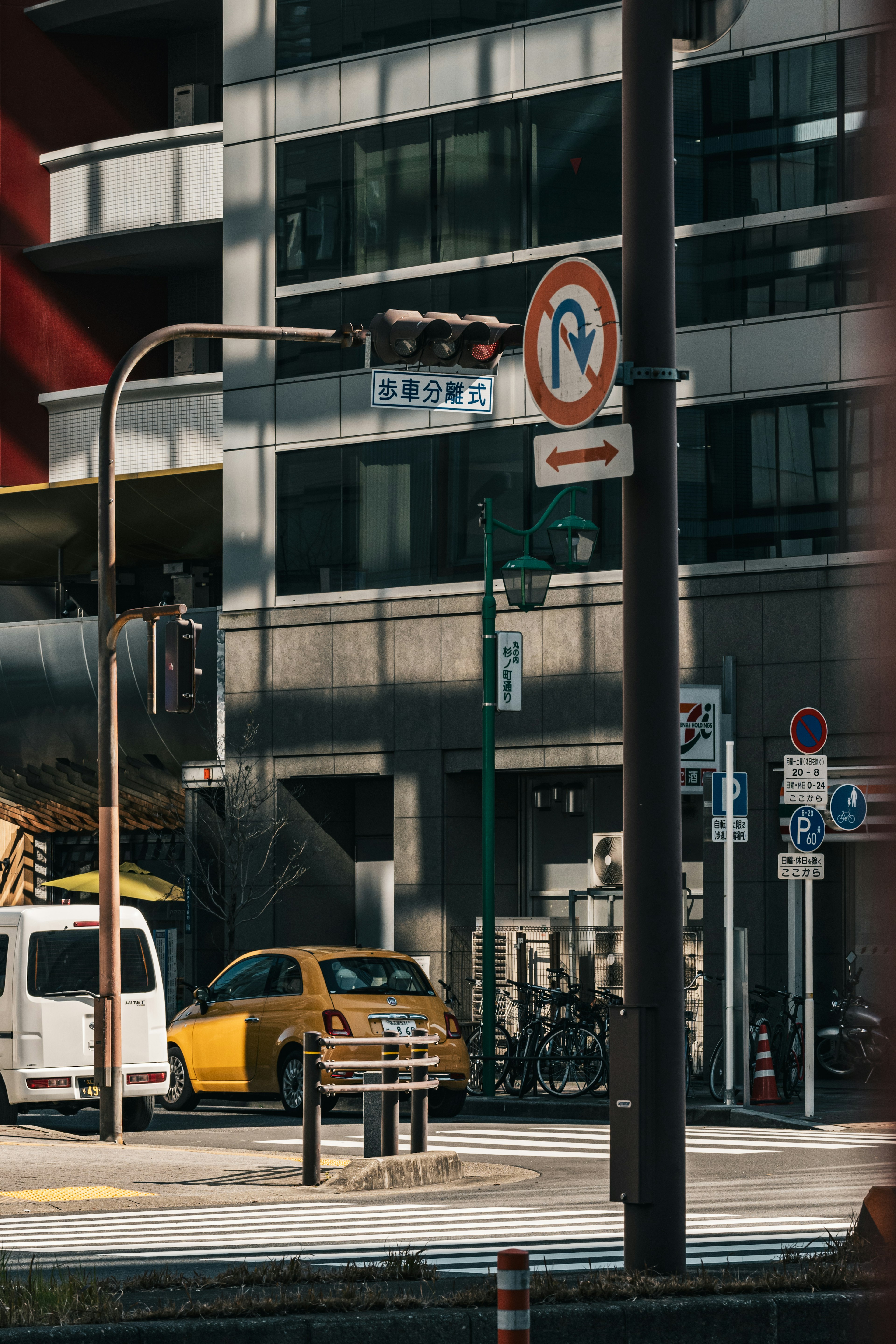 Yellow taxi at an urban intersection with parking signs