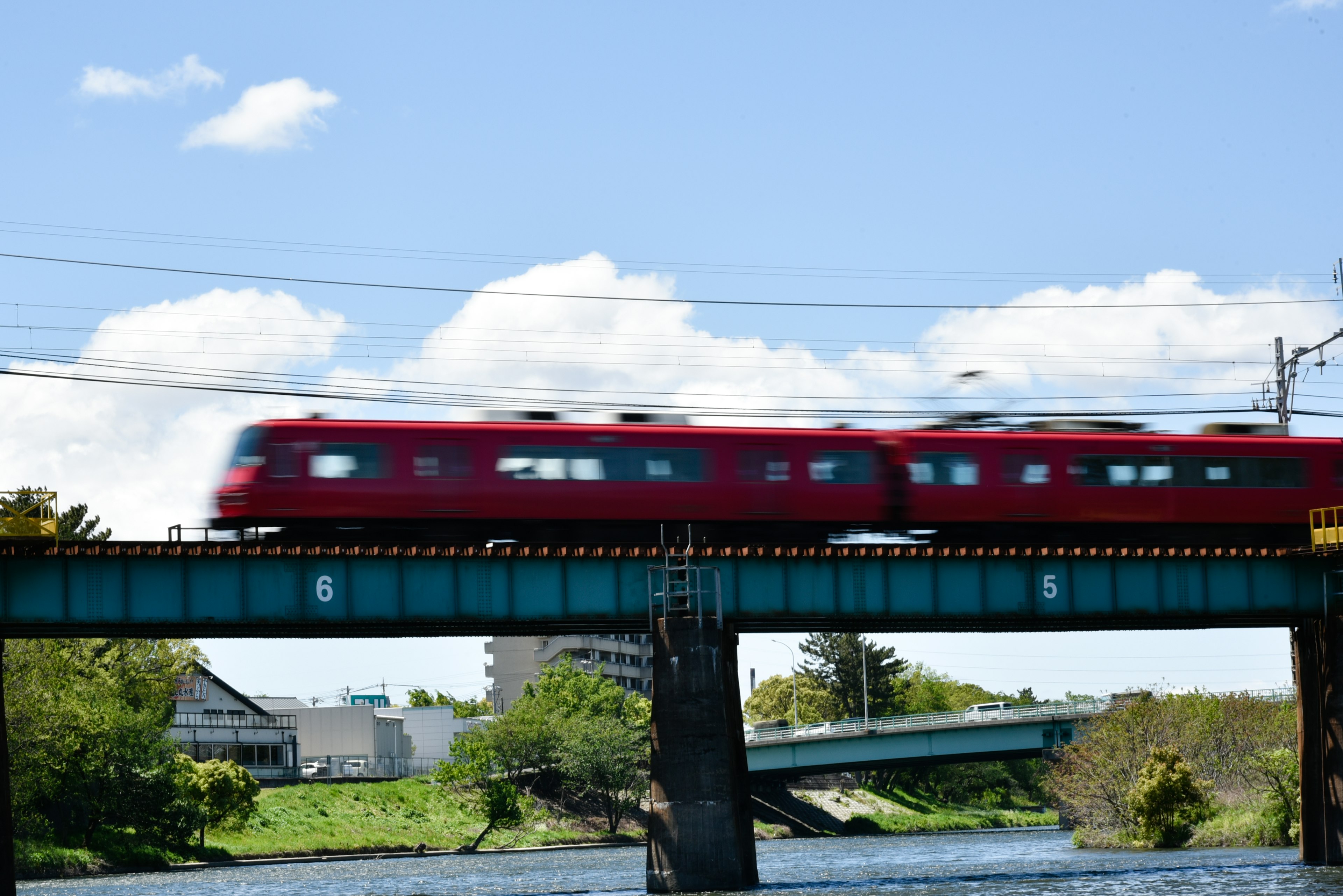 紅色火車穿過河上的橋