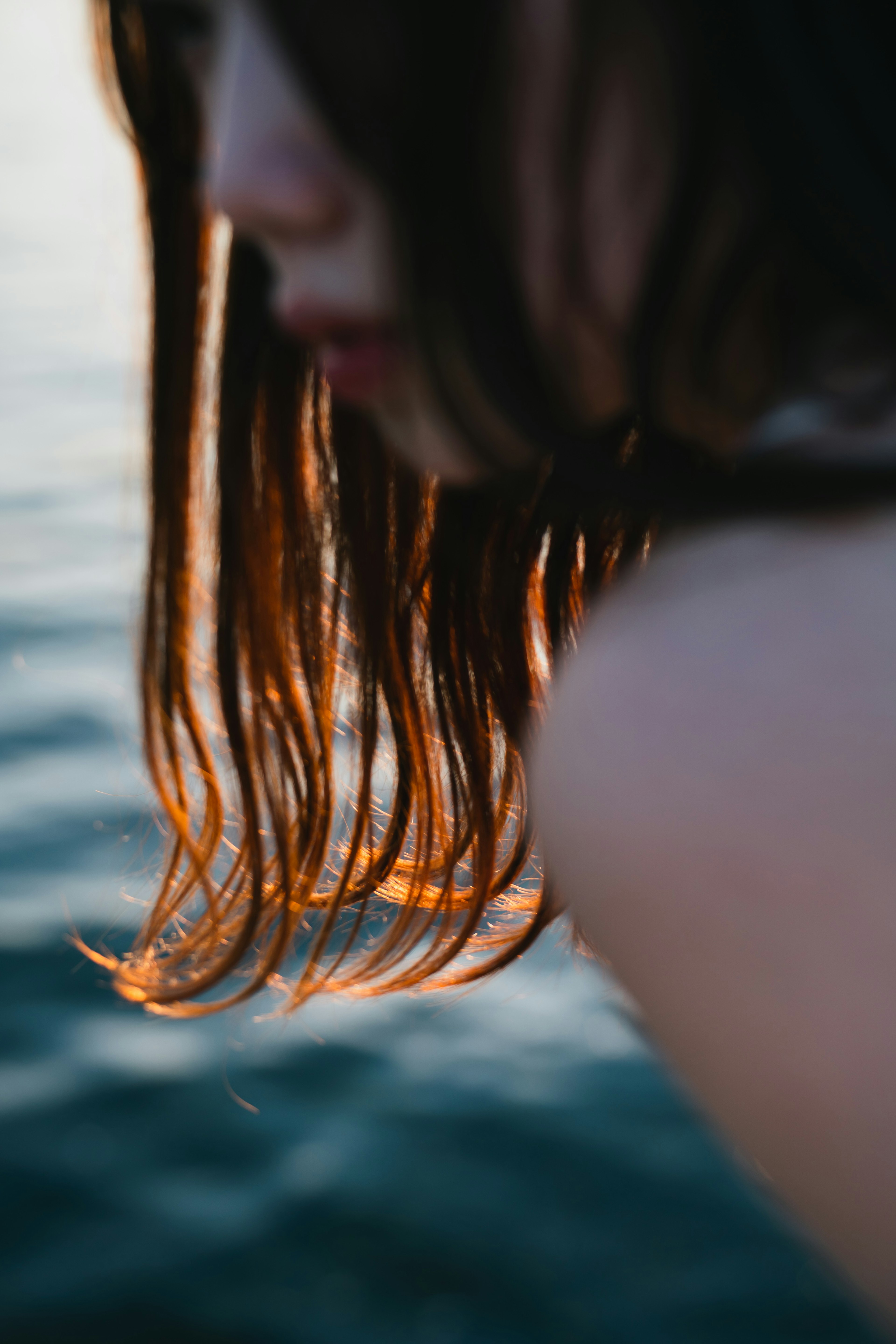 Close-up rambut dan bahu wanita di tepi air