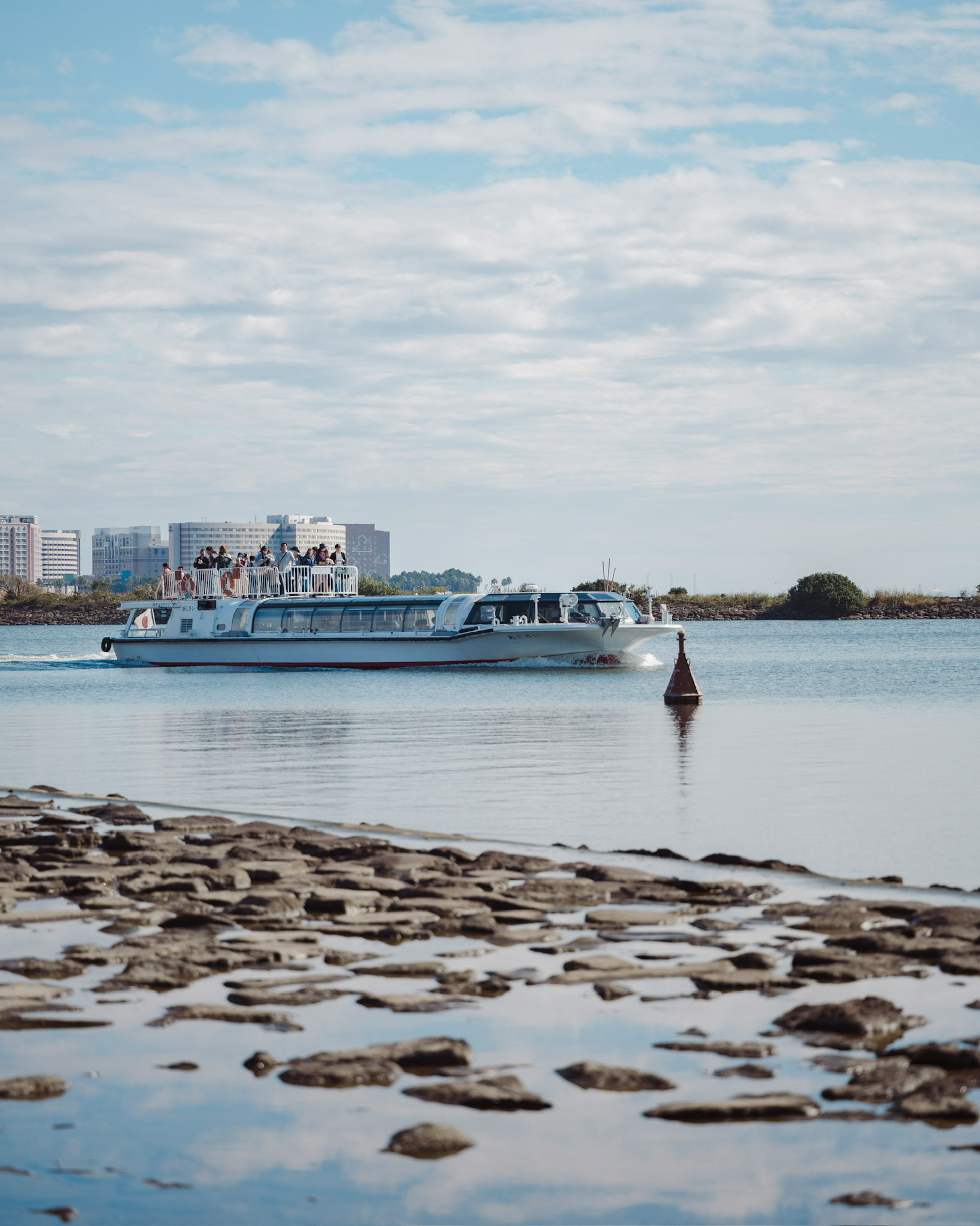 Un bateau glissant sur des eaux calmes avec une rive rocheuse