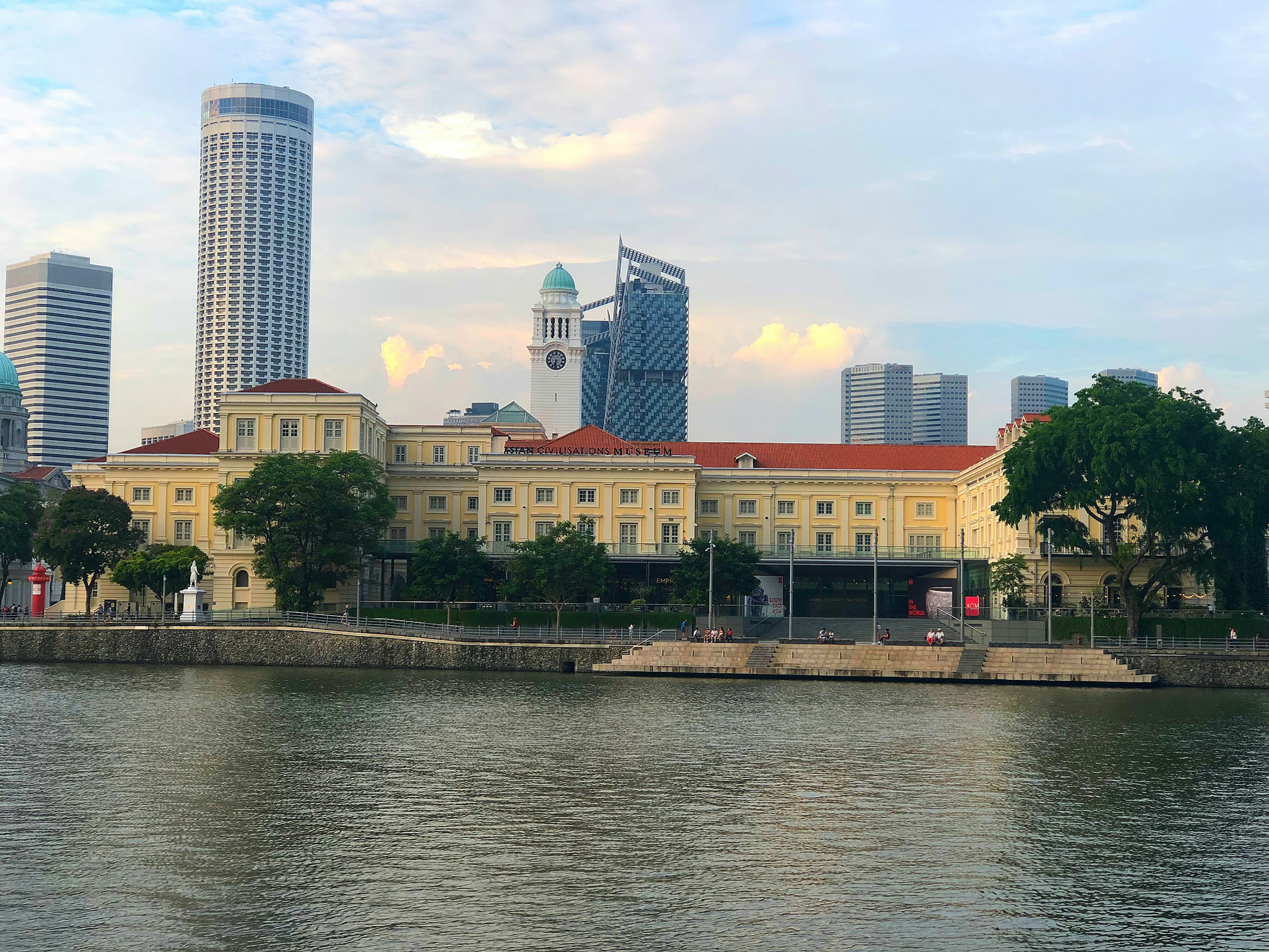 Historic building along the river with modern skyscrapers in Singapore