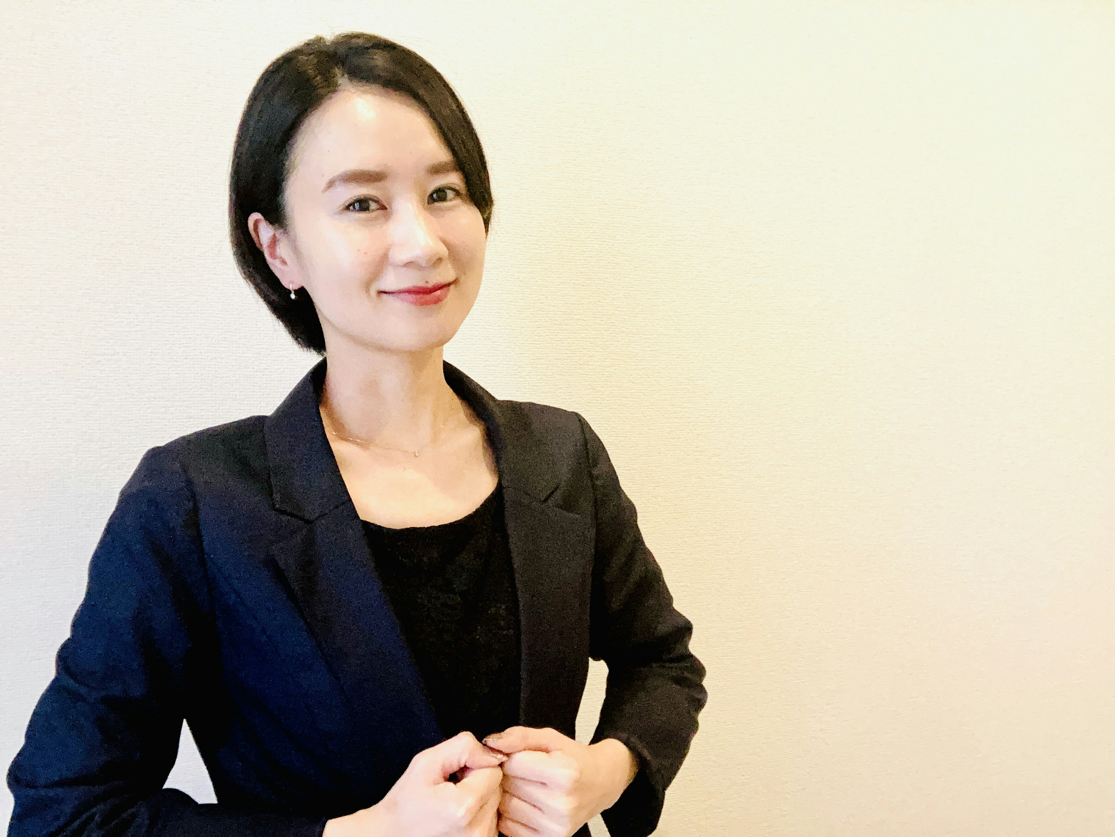 A woman in a suit smiling and posing