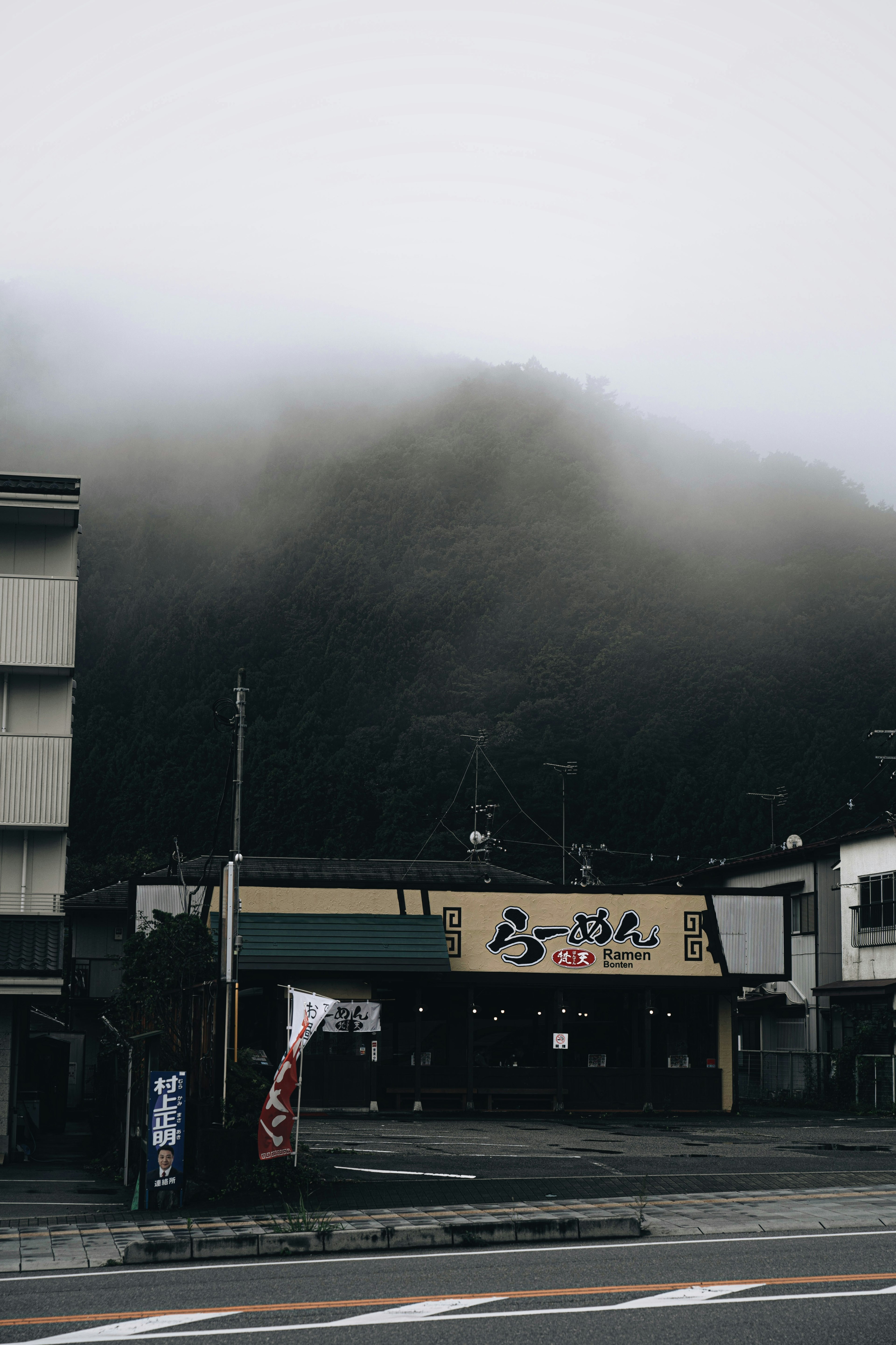 Paisaje montañoso cubierto de niebla con una pequeña tienda