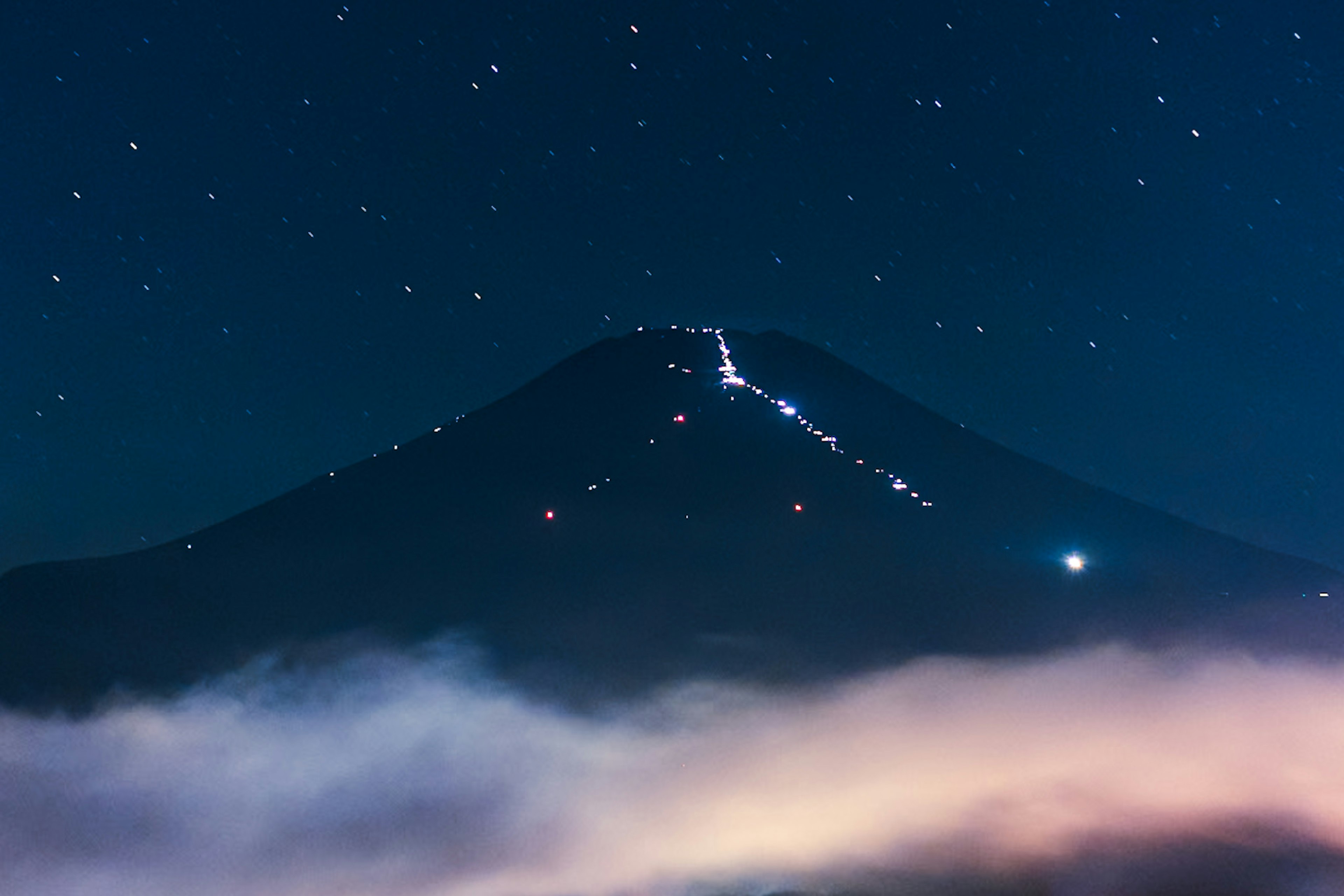 Pemandangan gunung di bawah langit berbintang Bintang-bintang cerah dan lautan awan