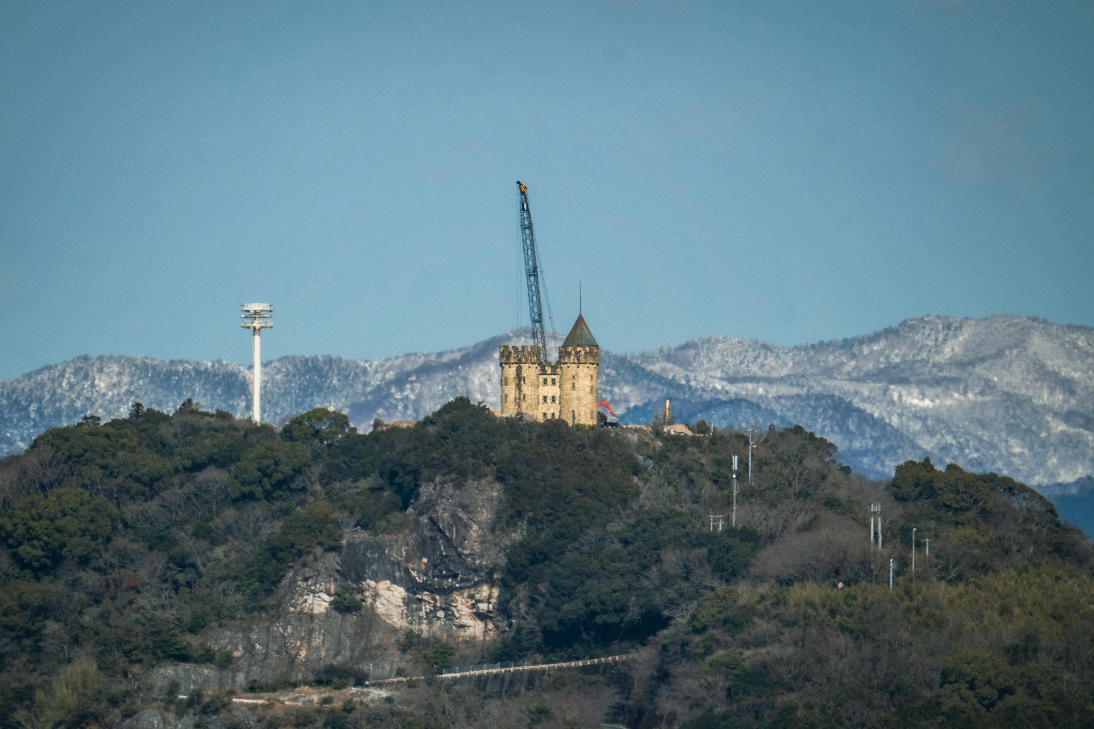 山顶上的施工塔和背景中的雪山