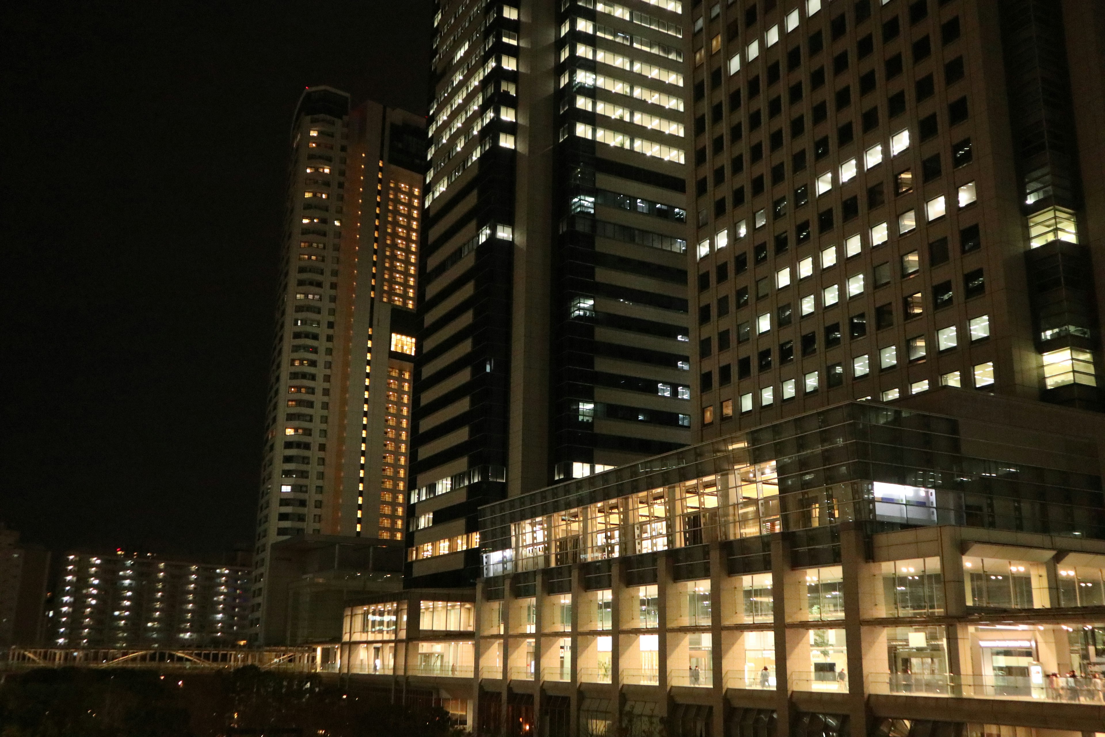 Pemandangan malam gedung pencakar langit dengan jendela yang menyala