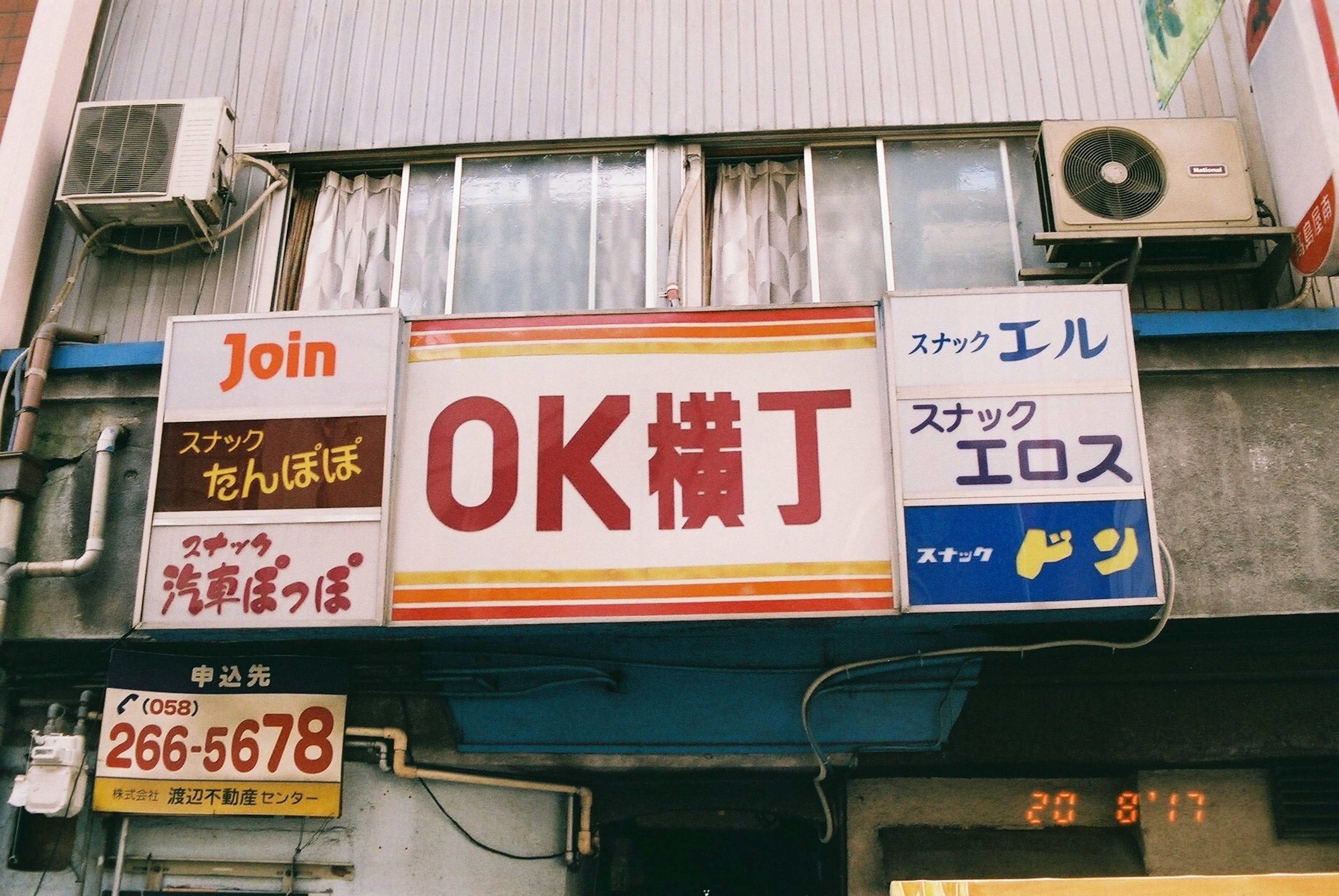 Panneau pour OK Yokocho avec des panneaux de magasins environnants