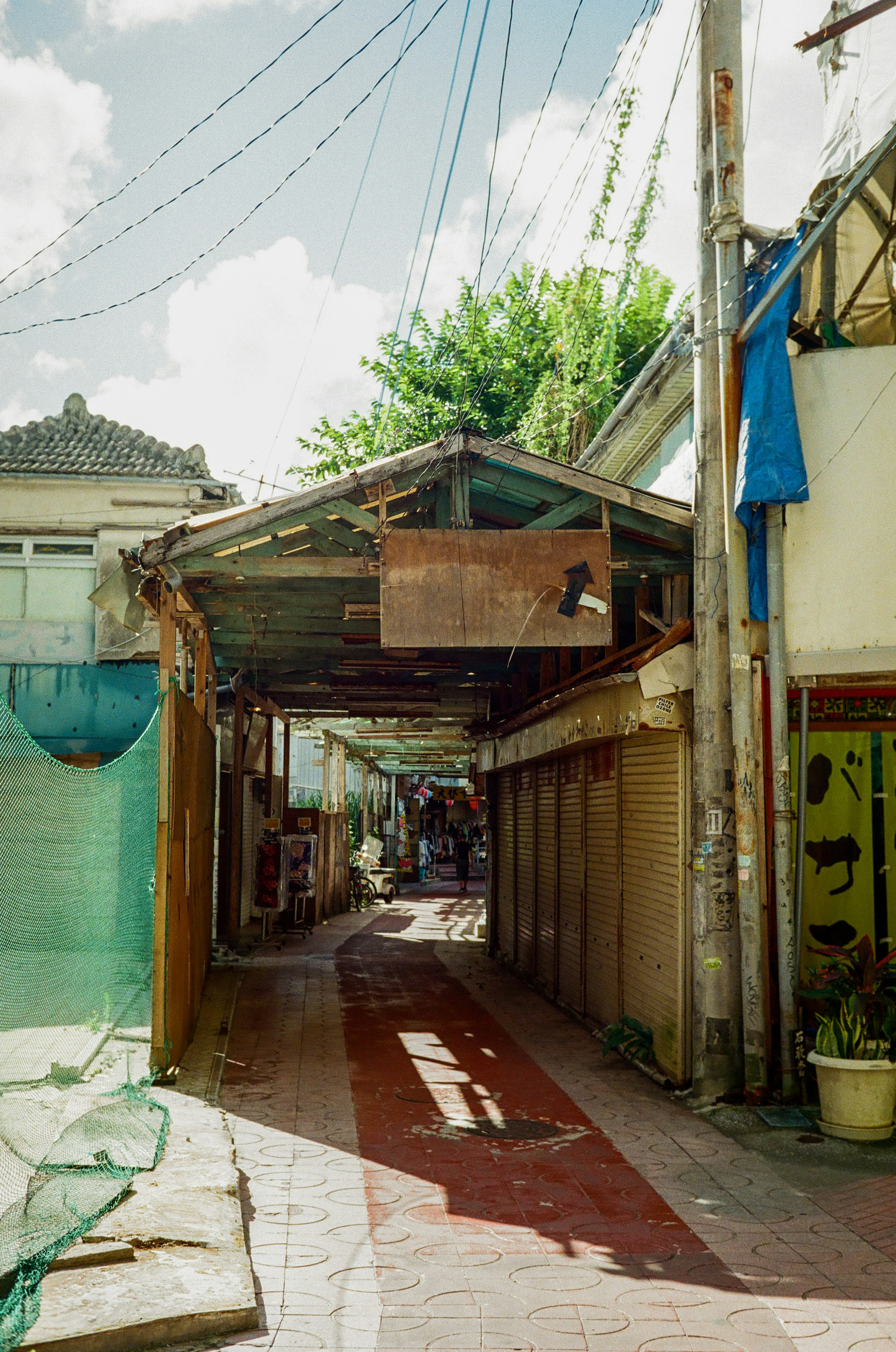 Narrow alleyway with a covered walkway and shops along the sides