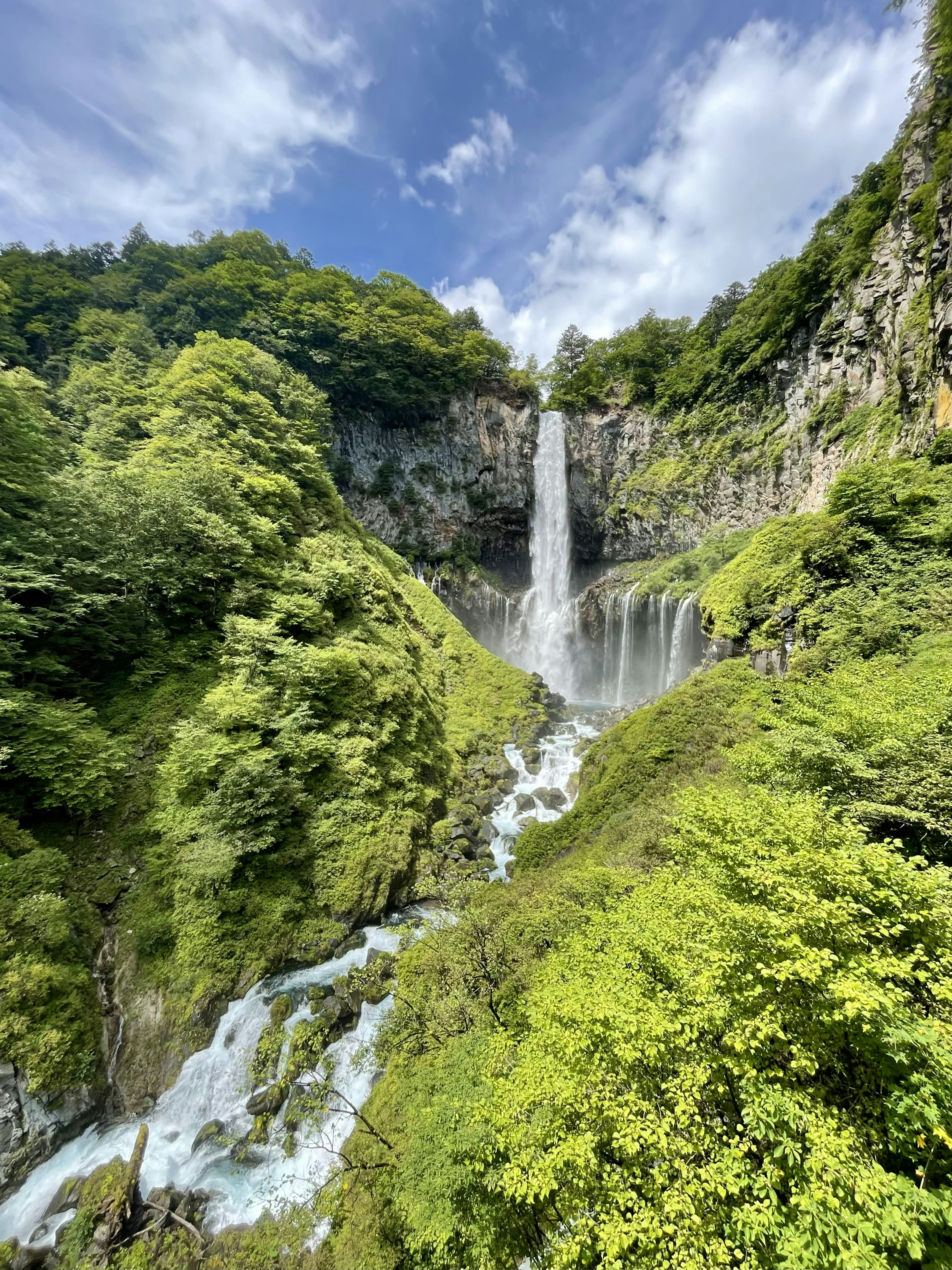 Ein schöner Wasserfall, der durch üppige grüne Berge fließt