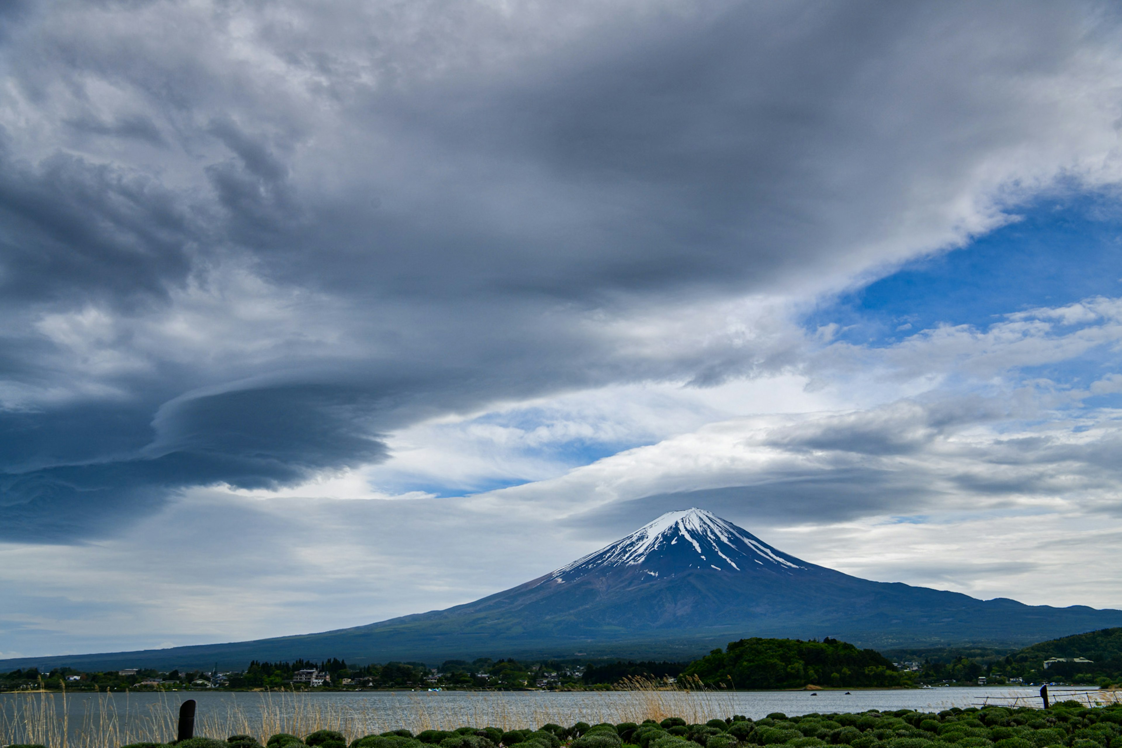 Gunung Fuji di bawah langit dramatis dengan awan dan nuansa biru