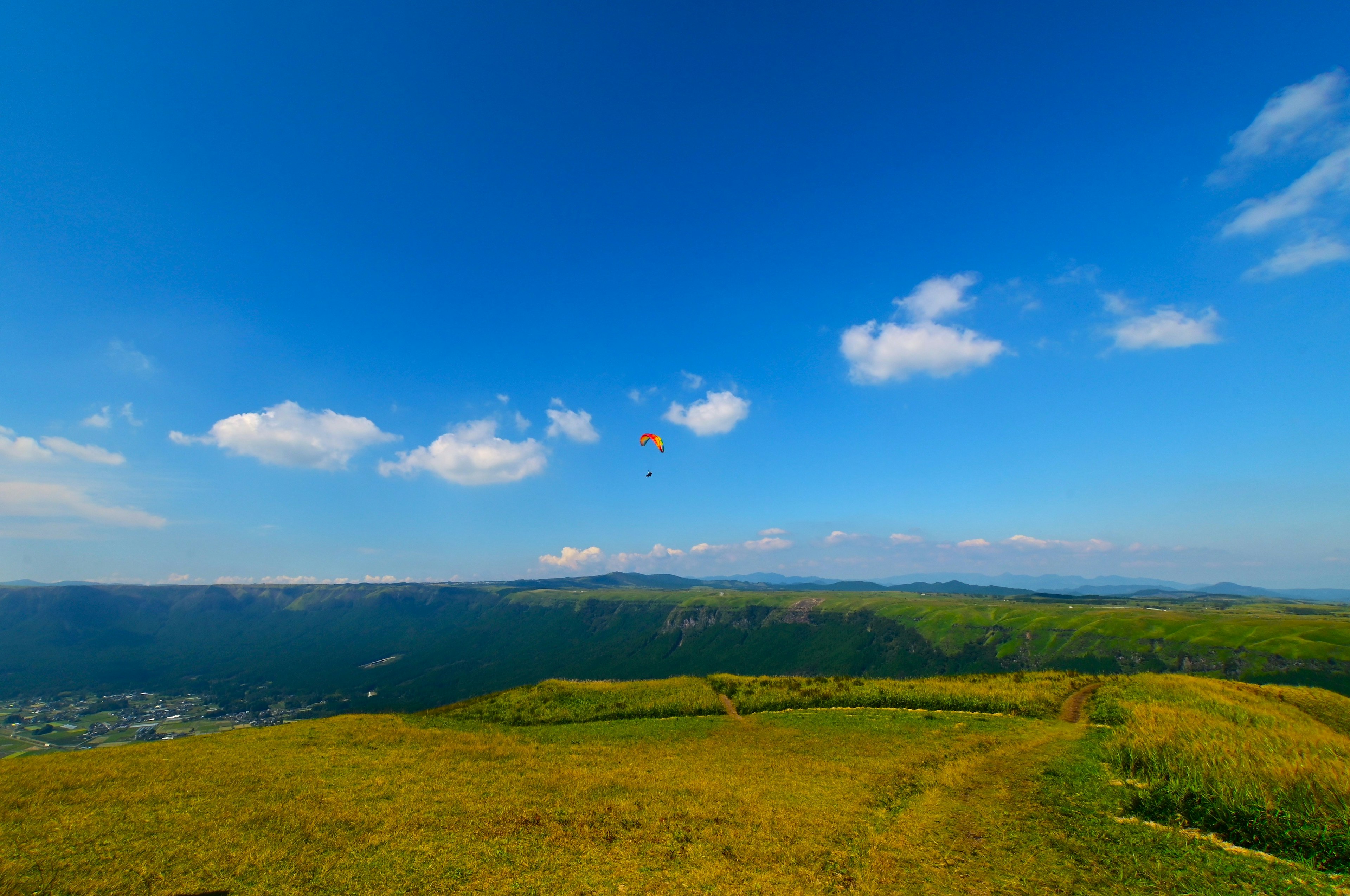 青空と白い雲が広がる山の風景 緑の丘と草原が広がる