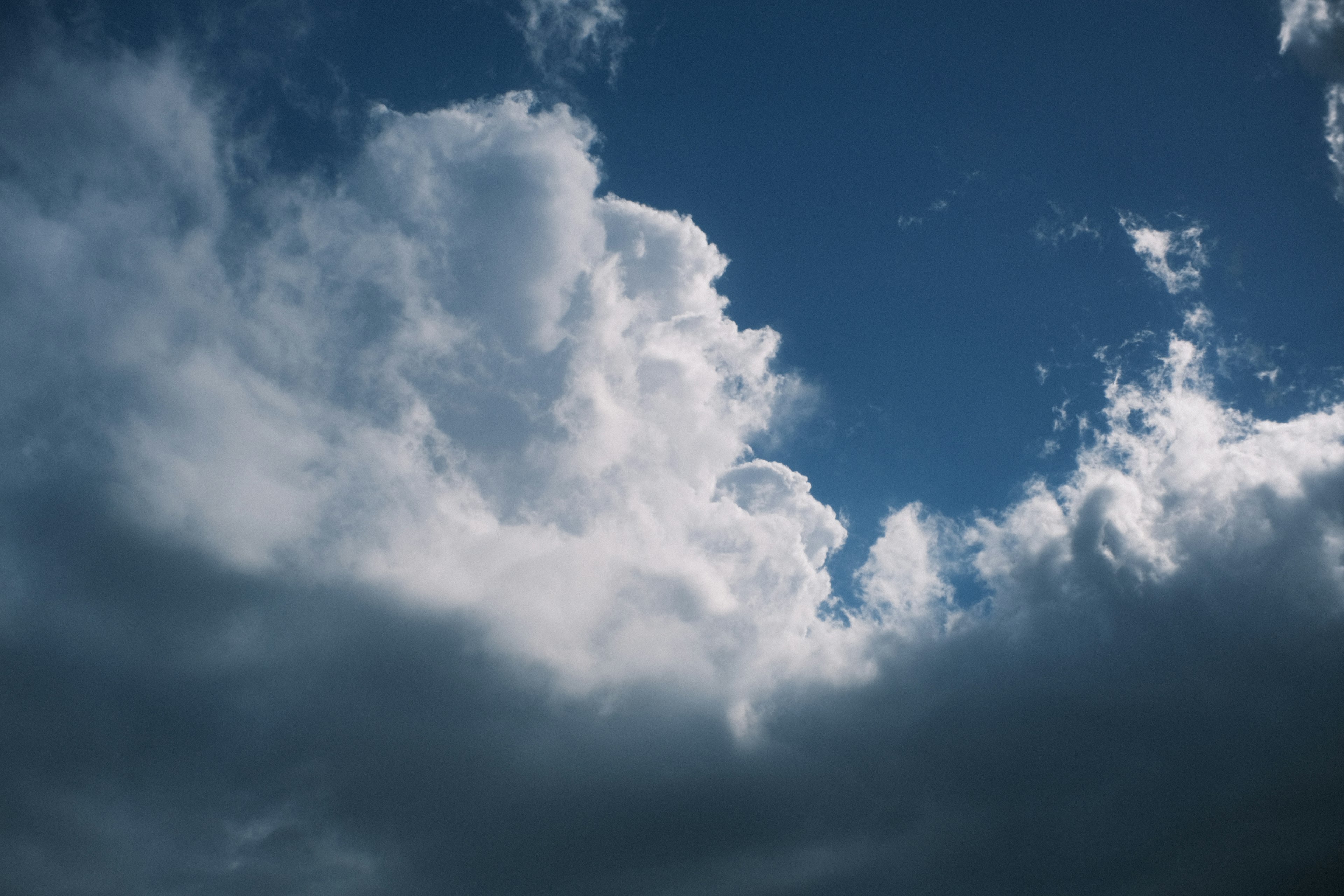 Kontrast zwischen weißen und dunklen Wolken vor einem blauen Himmel