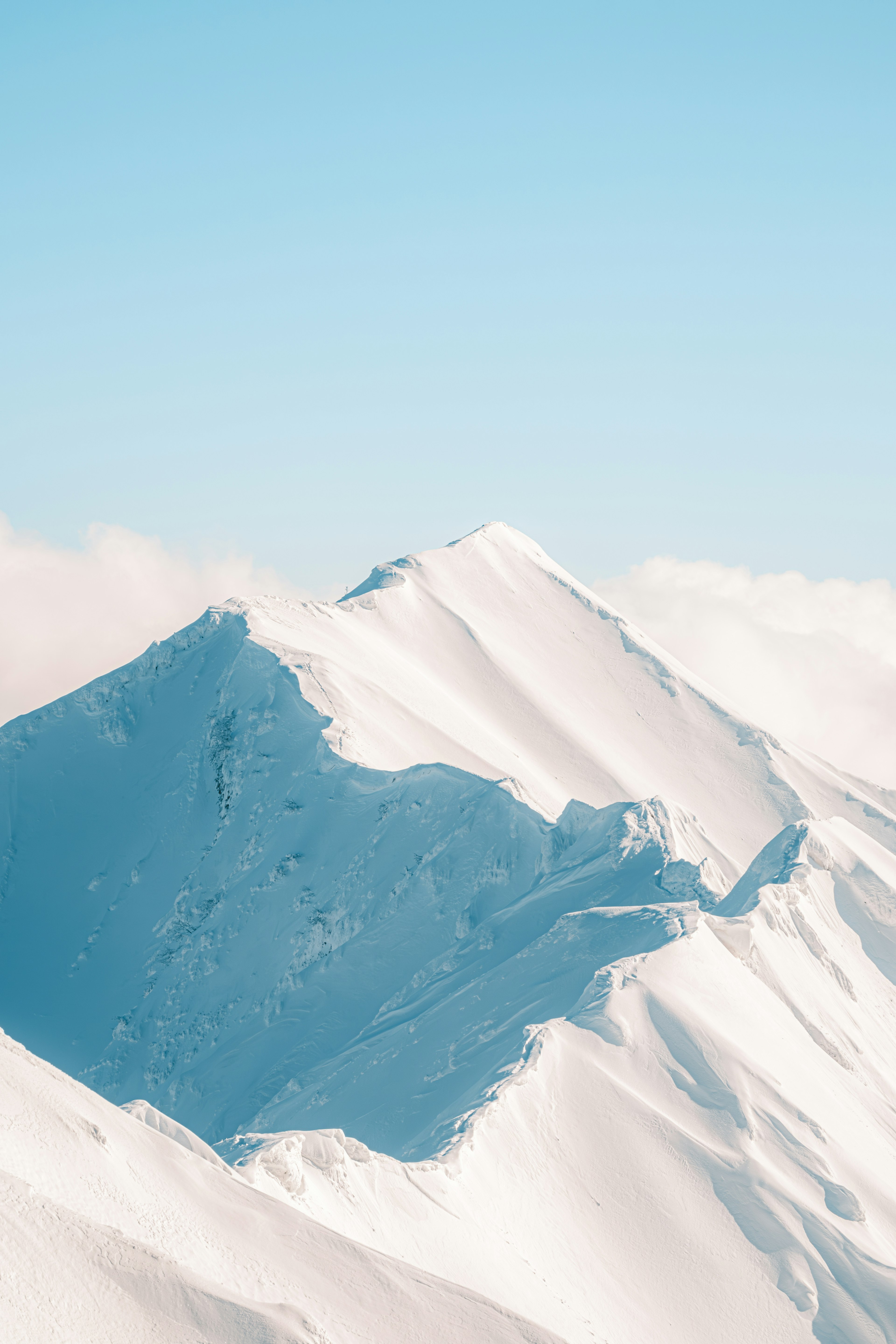 Montagne innevate sotto un cielo blu chiaro