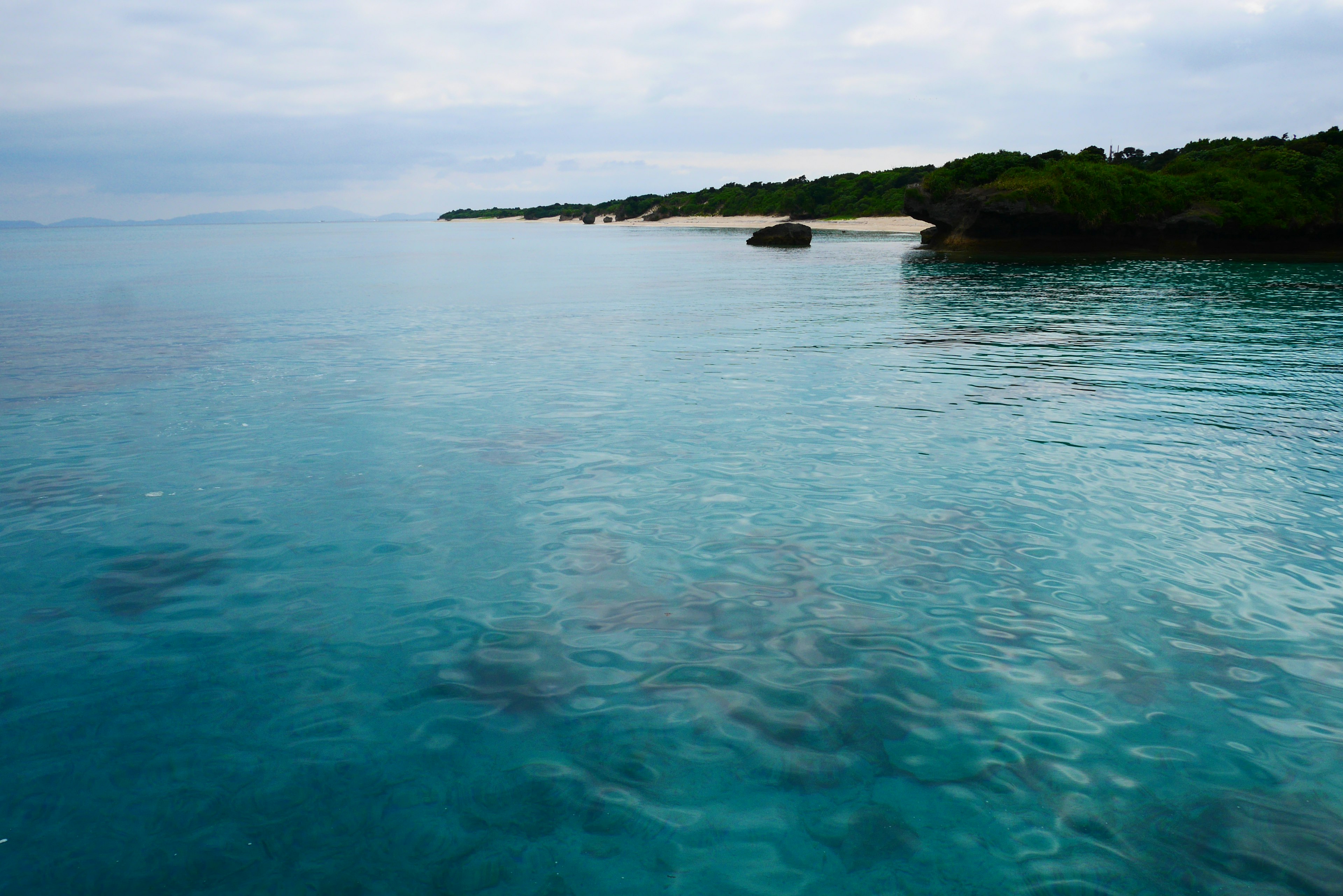 Clear turquoise water with lush green coastline