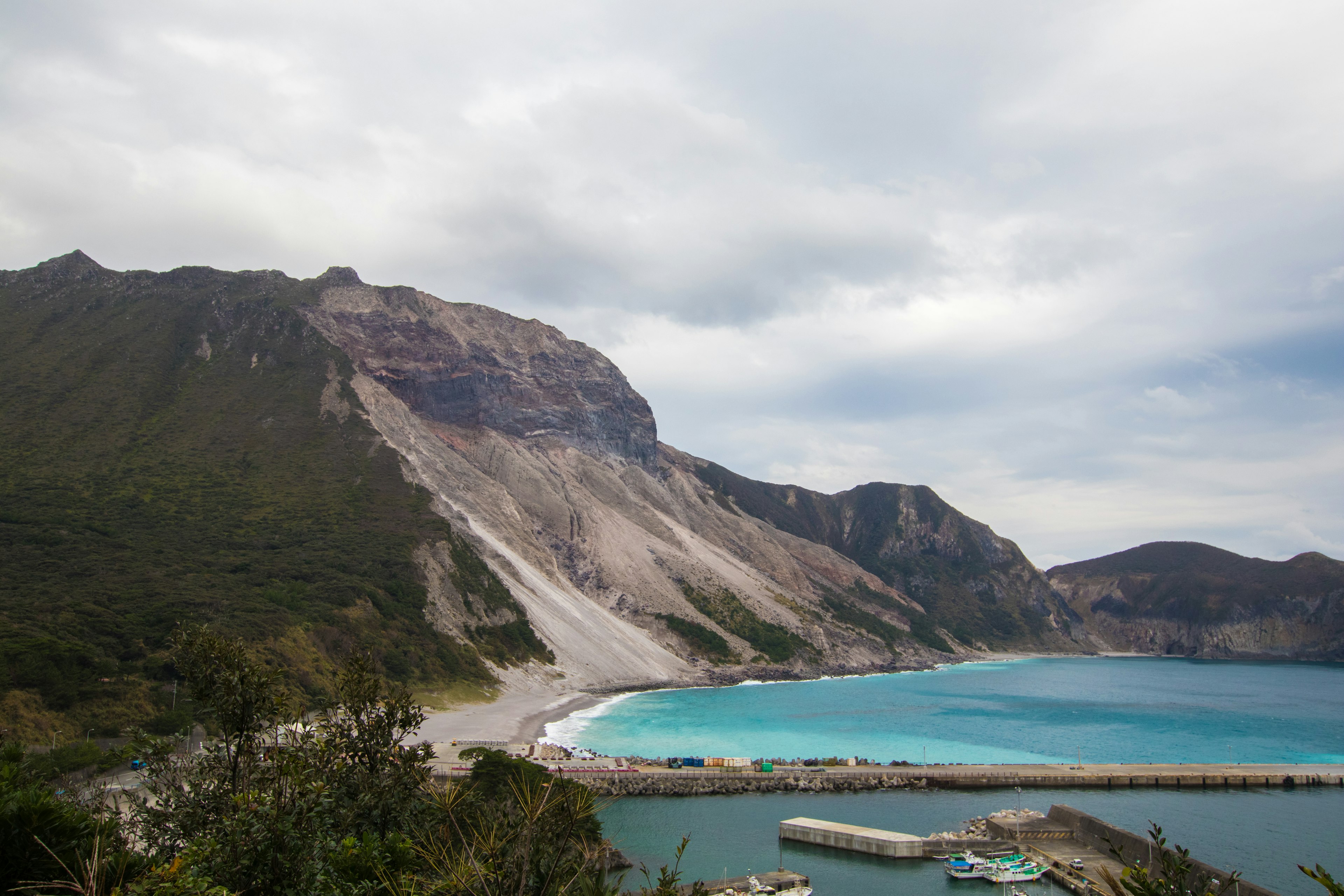 Vista escénica de la costa y las montañas con agua azul clara