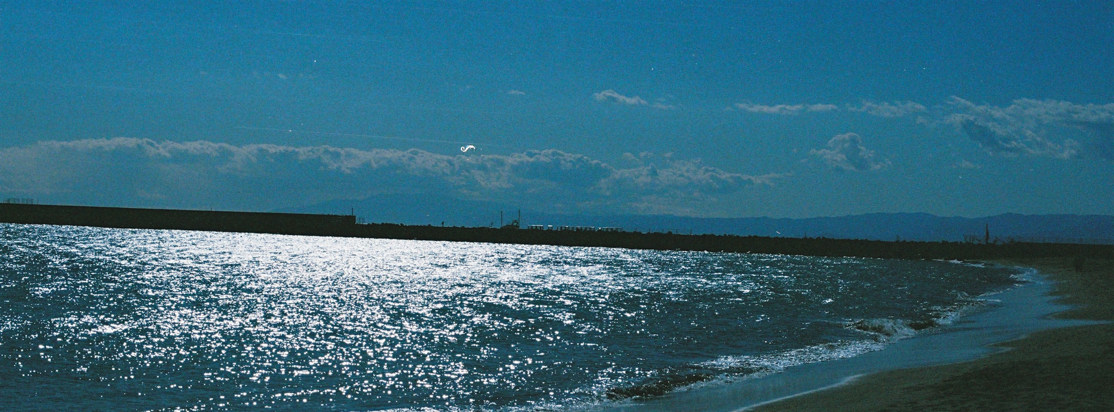 Panoramablick auf das blaue Meer und den Himmel mit sanften Wellenreflexionen