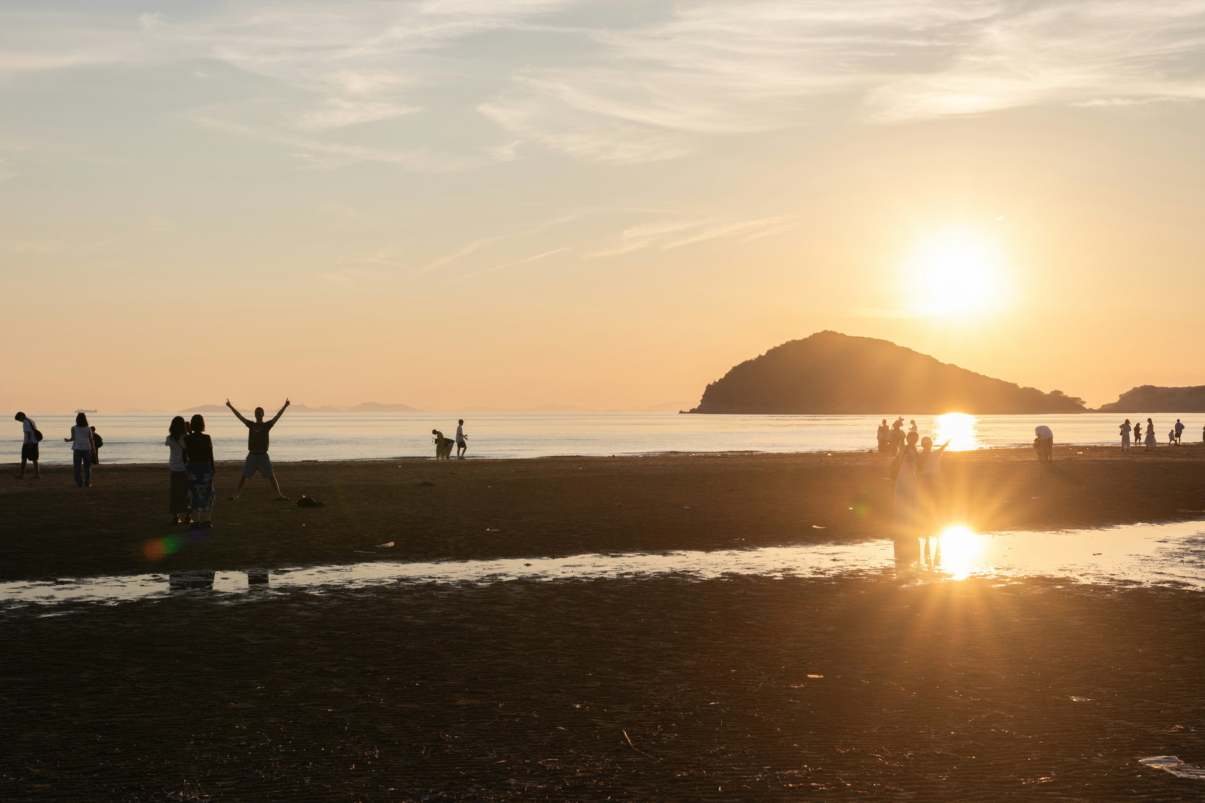 Silhouettes of people enjoying the beach at sunset