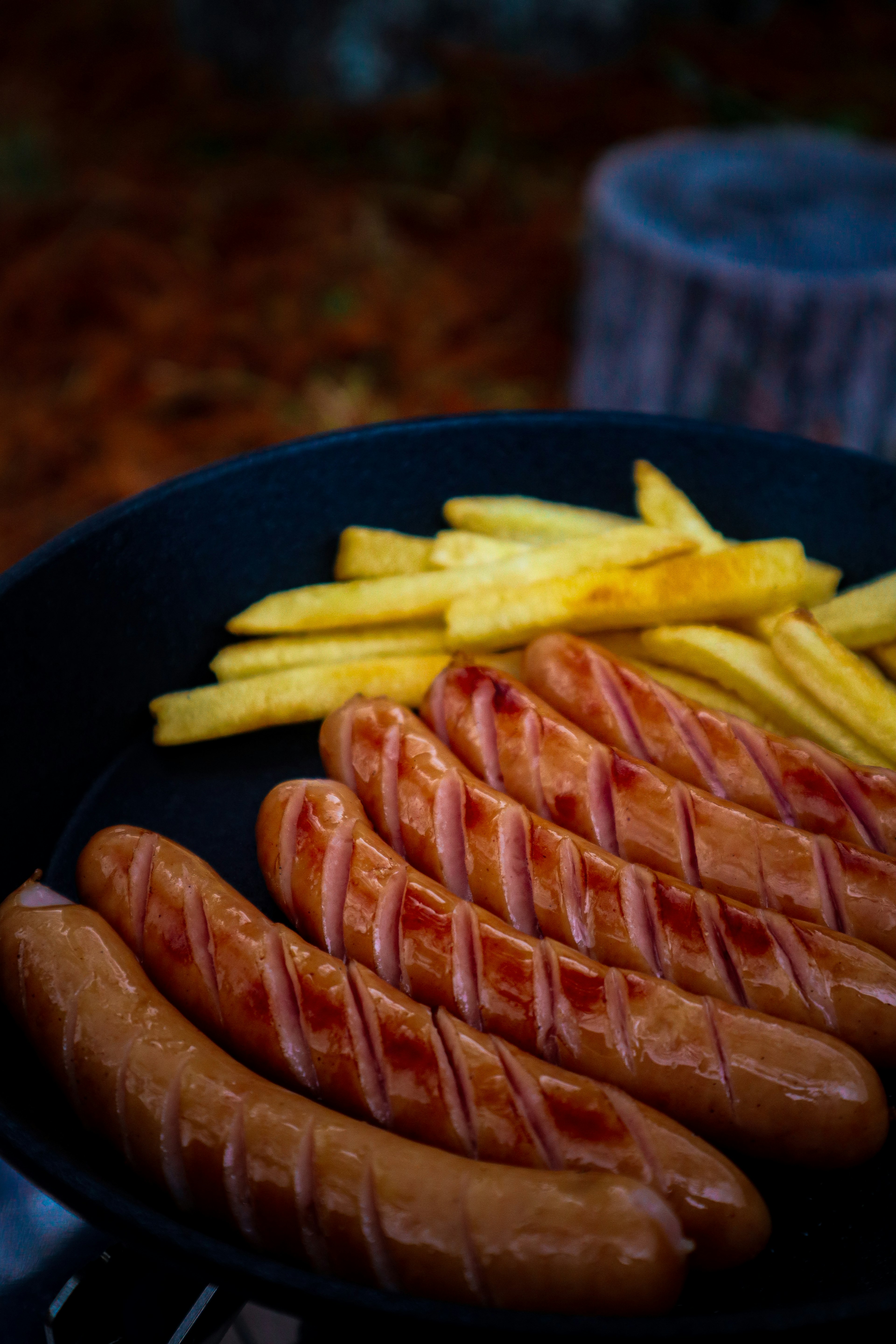 Image of sausages and French fries in a frying pan