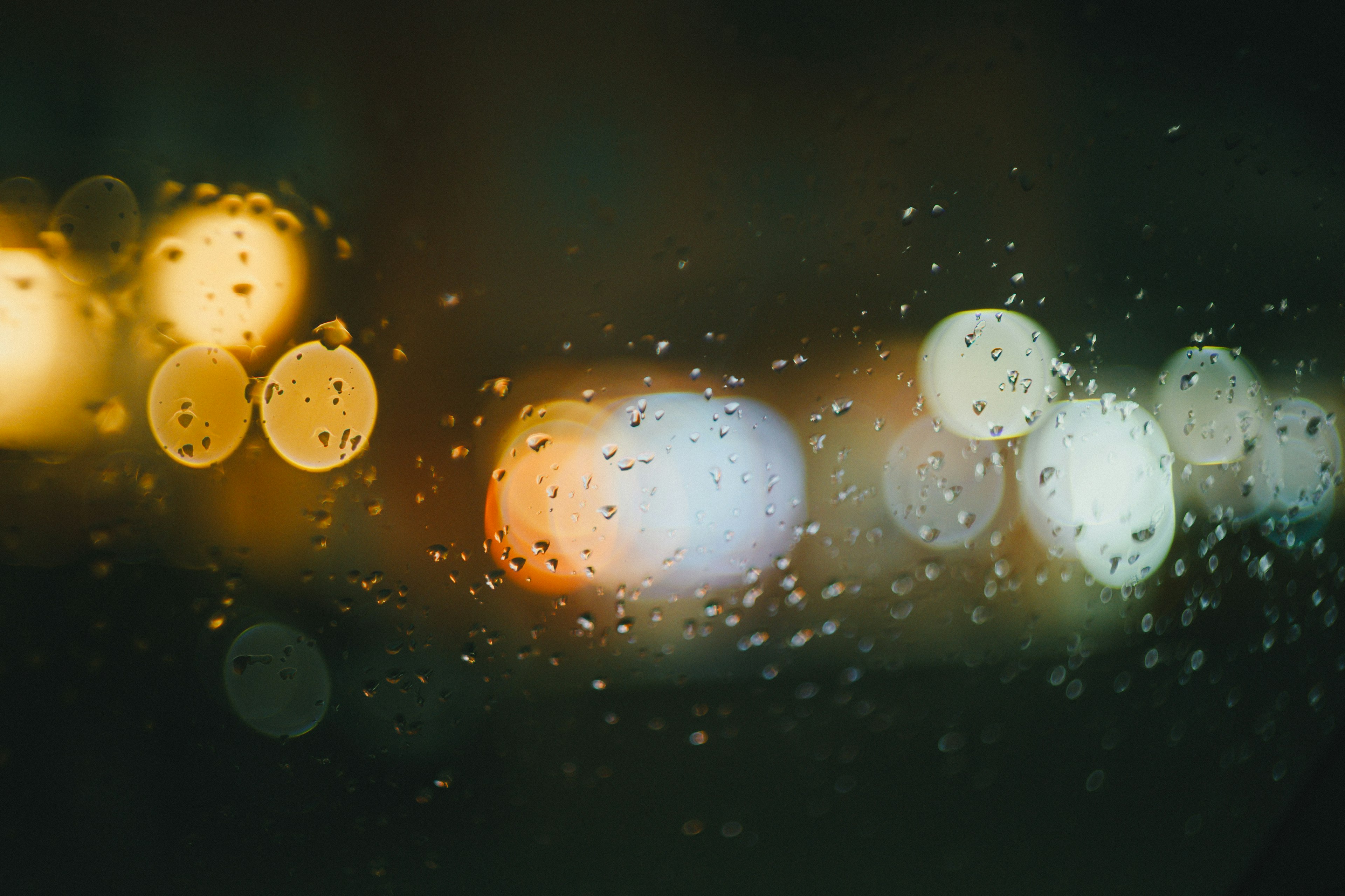 透过雨水滴落的窗户看到的模糊夜景灯光