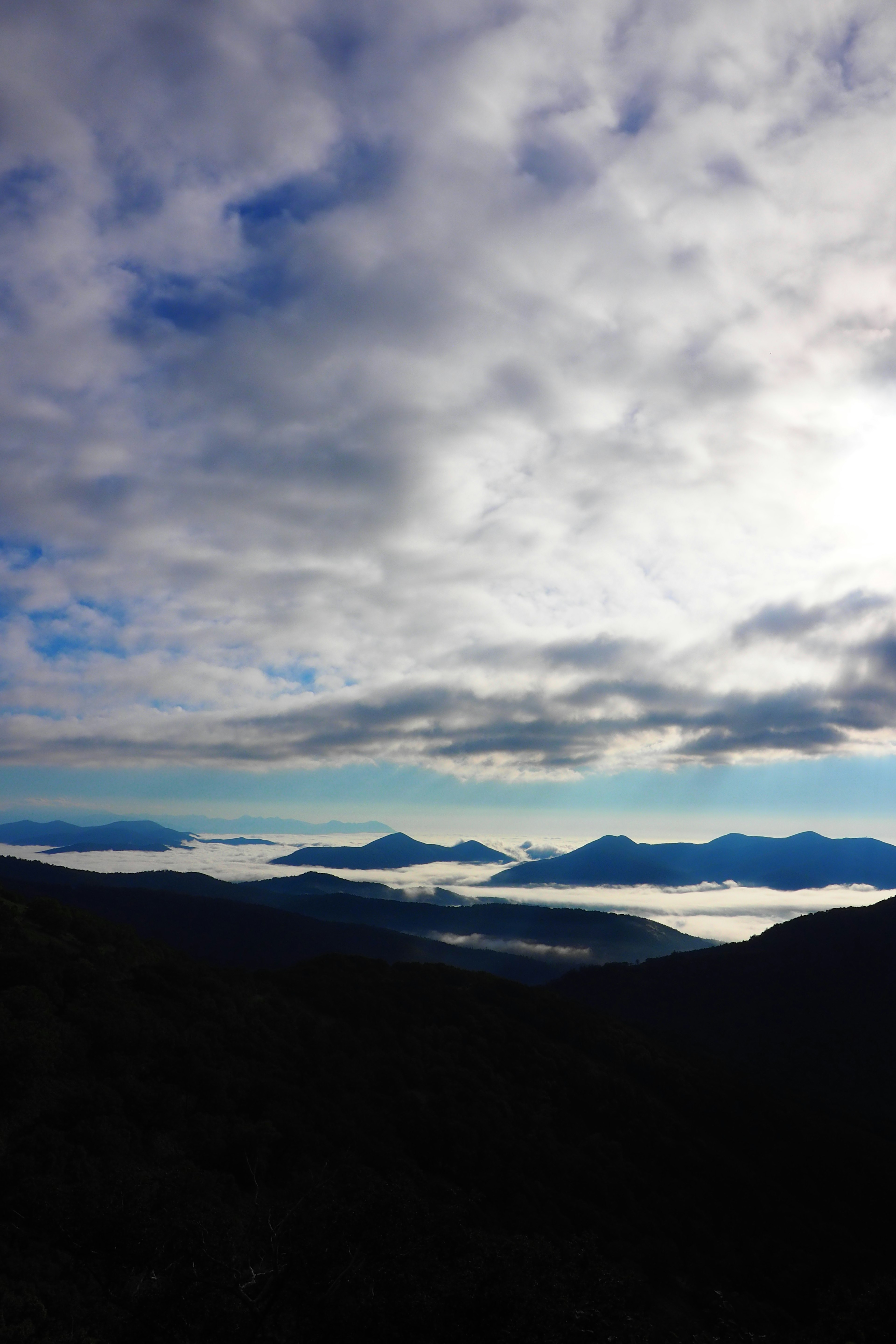 Landscape of mountains covered in mist with a cloudy sky