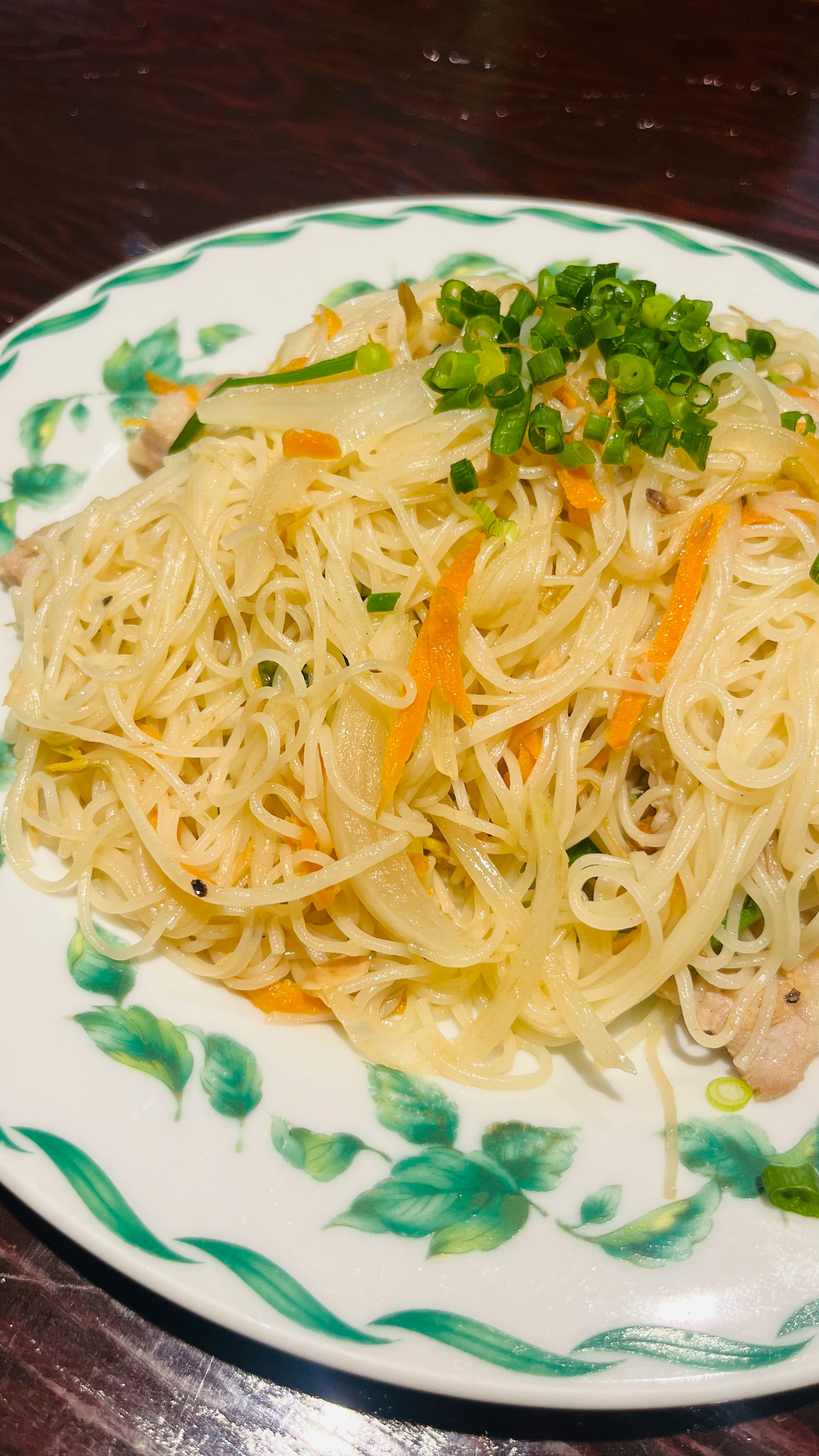 Plate of fine noodles topped with vegetables and green onions