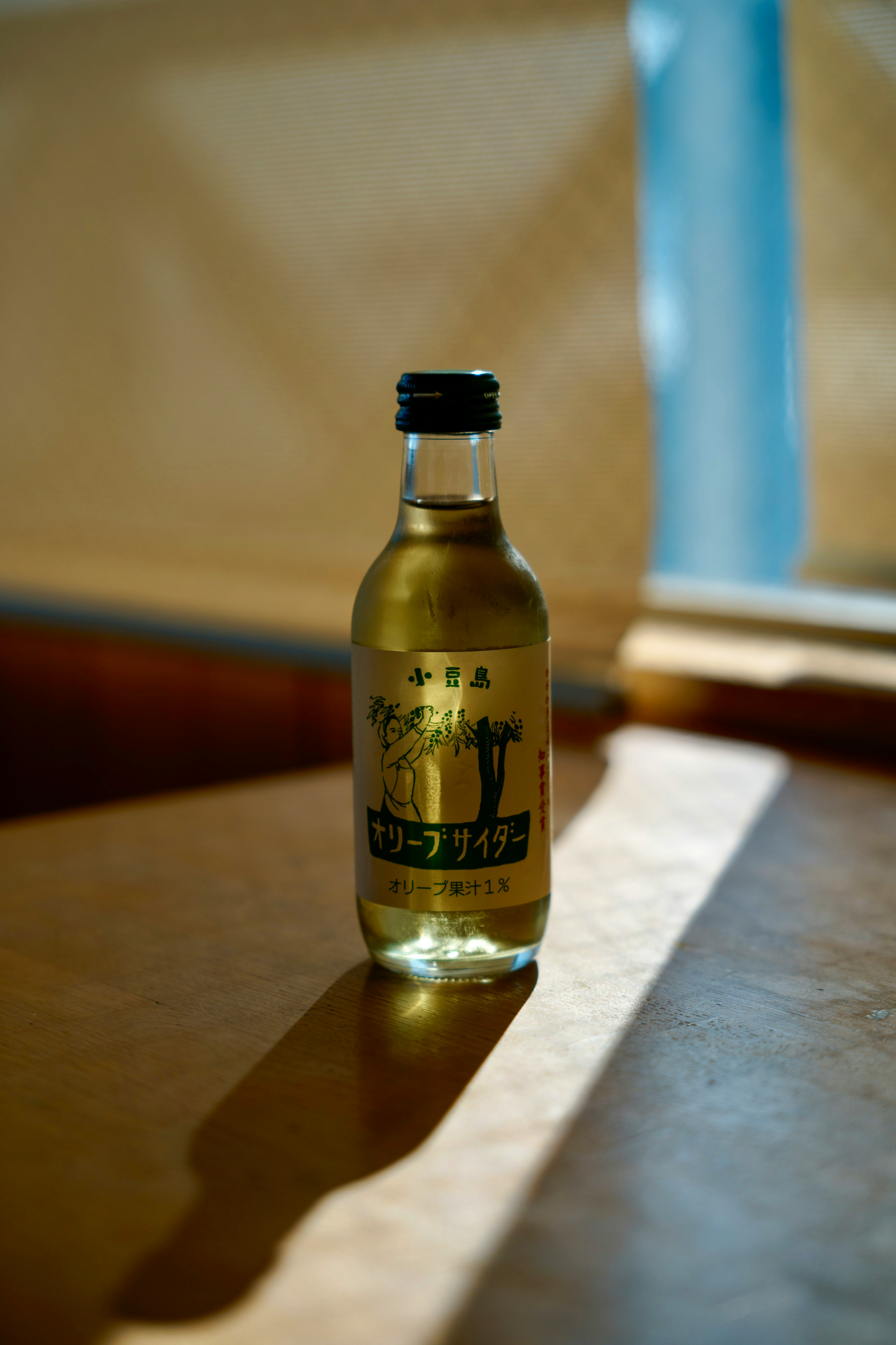 A green beverage bottle placed on a wooden table