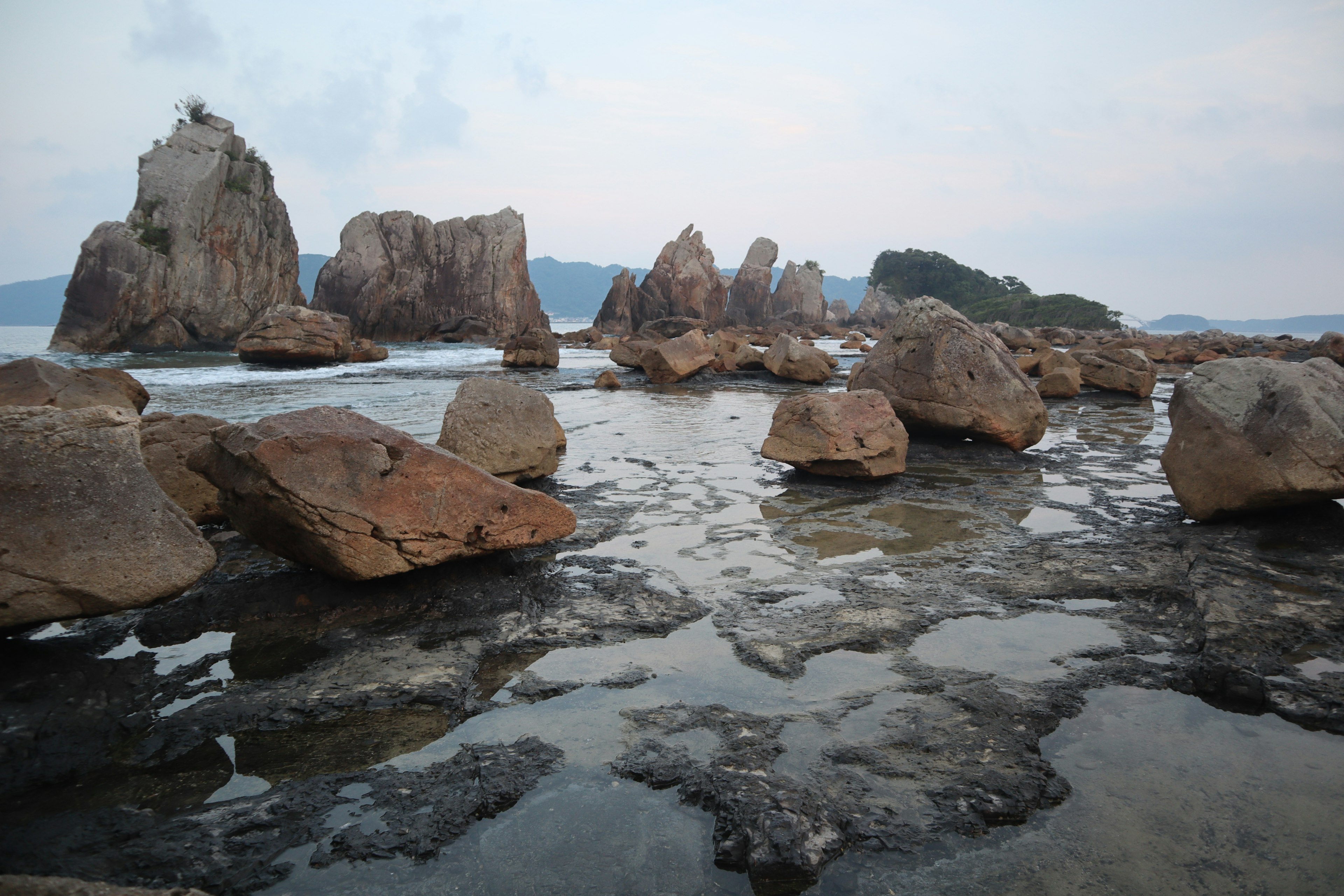 Scenic view of coastal rocks and calm water surface