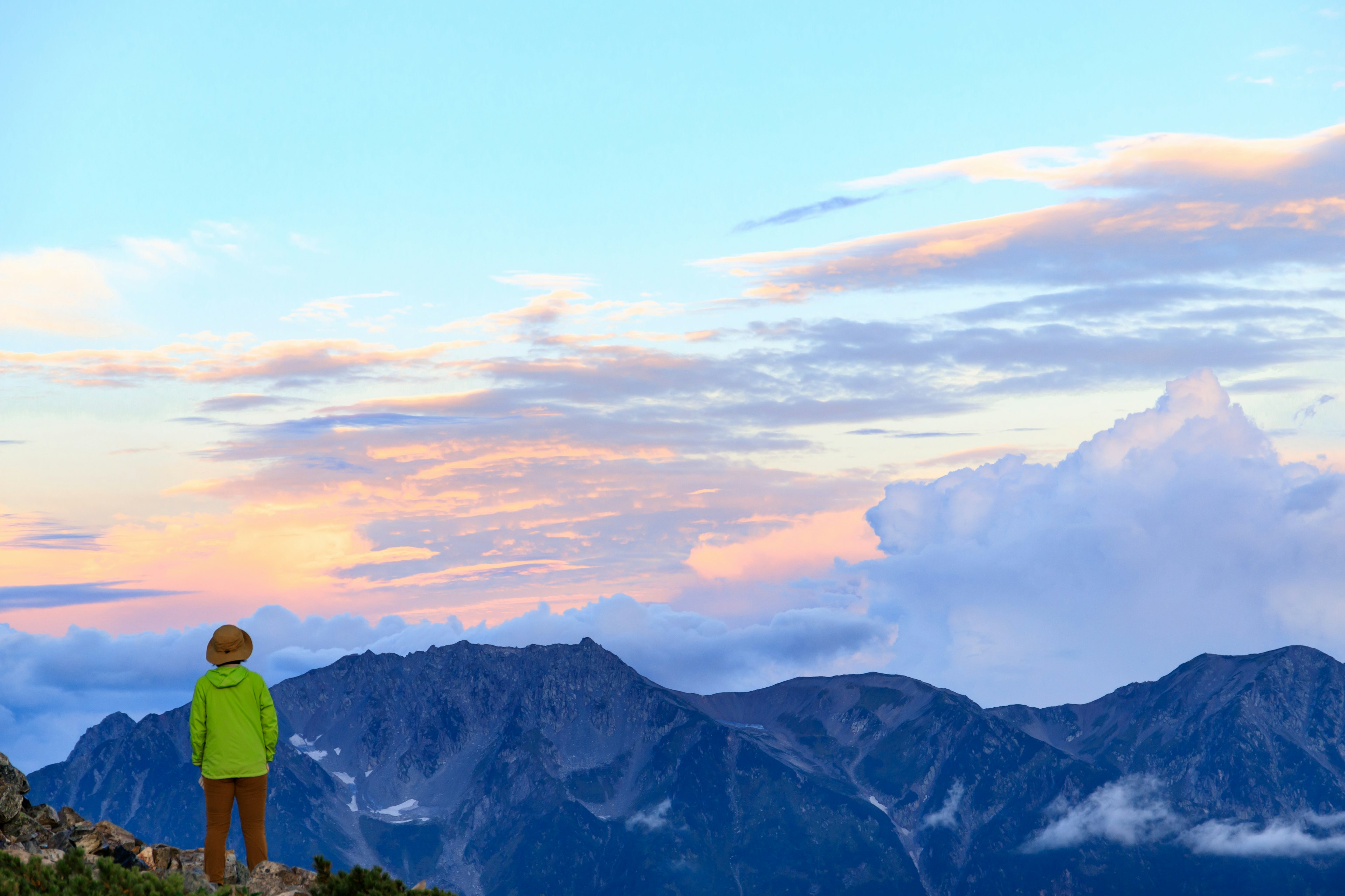 Bambino in piedi su una vetta di montagna con un bellissimo tramonto