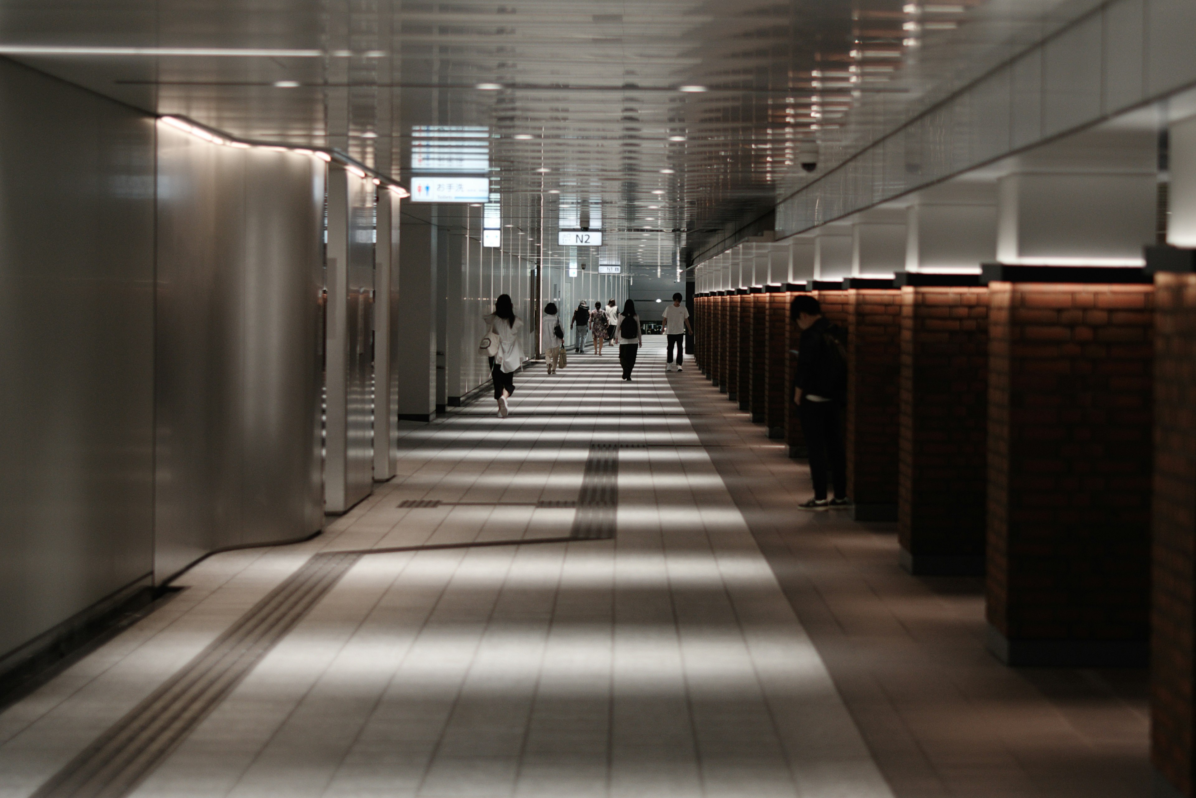 A modern hallway with people walking in the distance