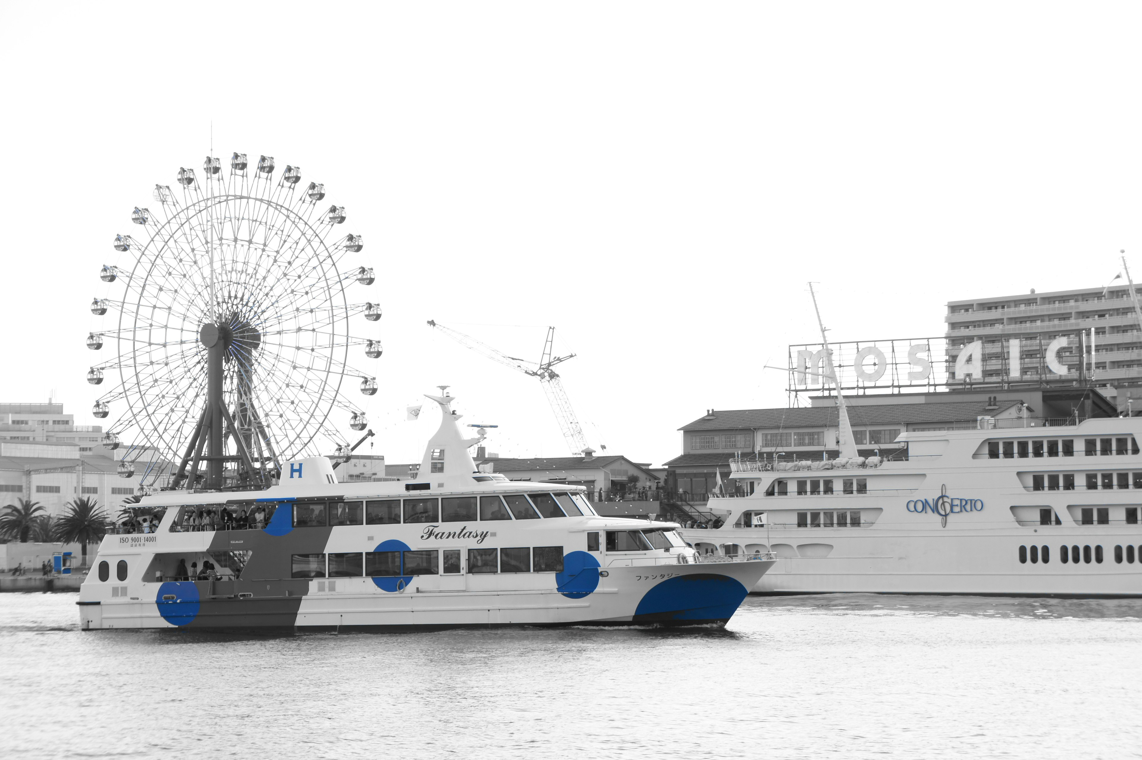 A ferry with blue dots alongside a ferris wheel in a harbor