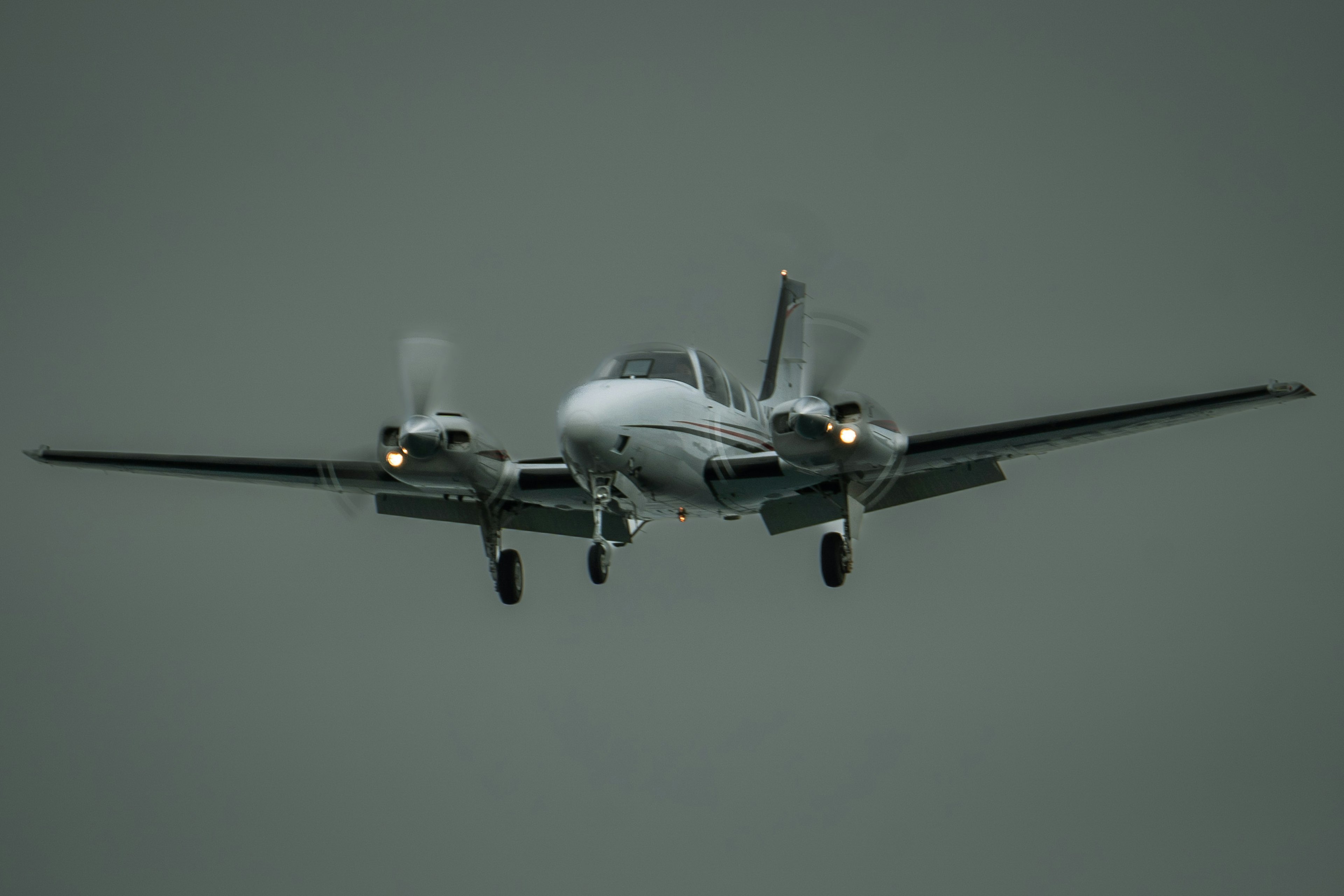 Petit avion atterrissant sous un ciel nuageux