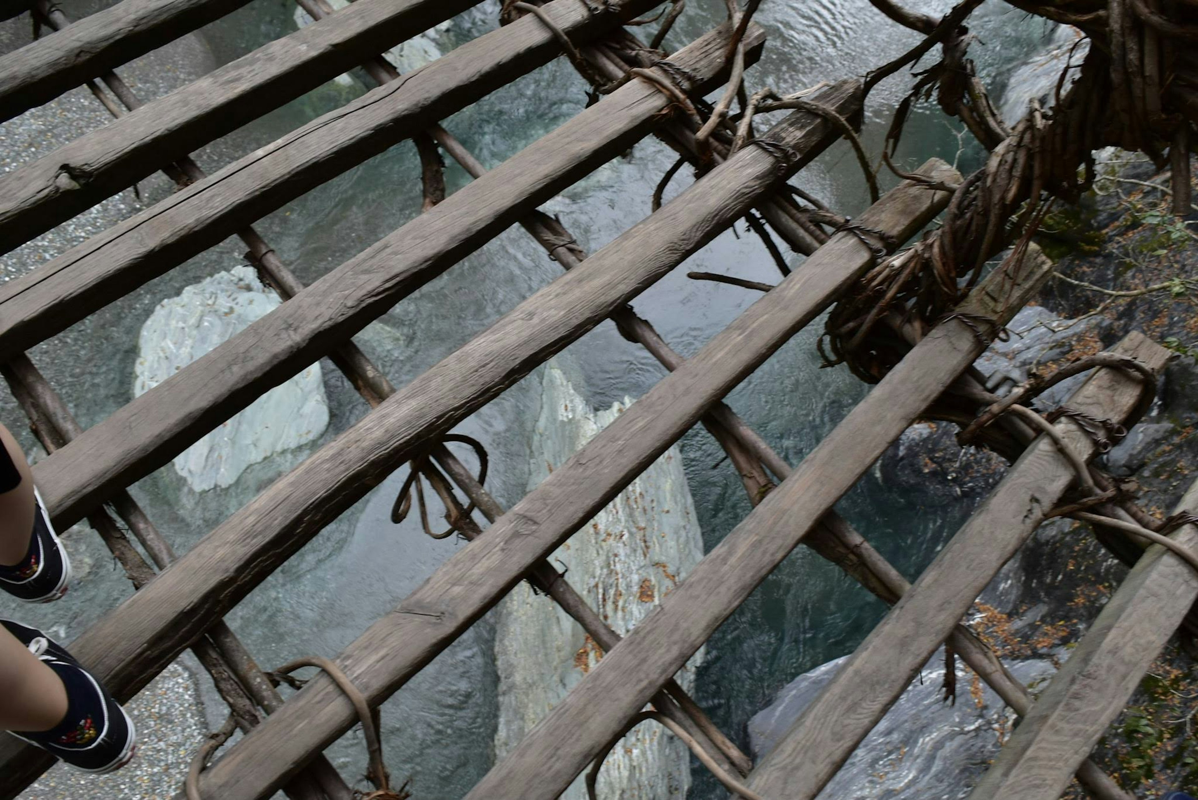 Wooden bridge structure with transparent floor above water