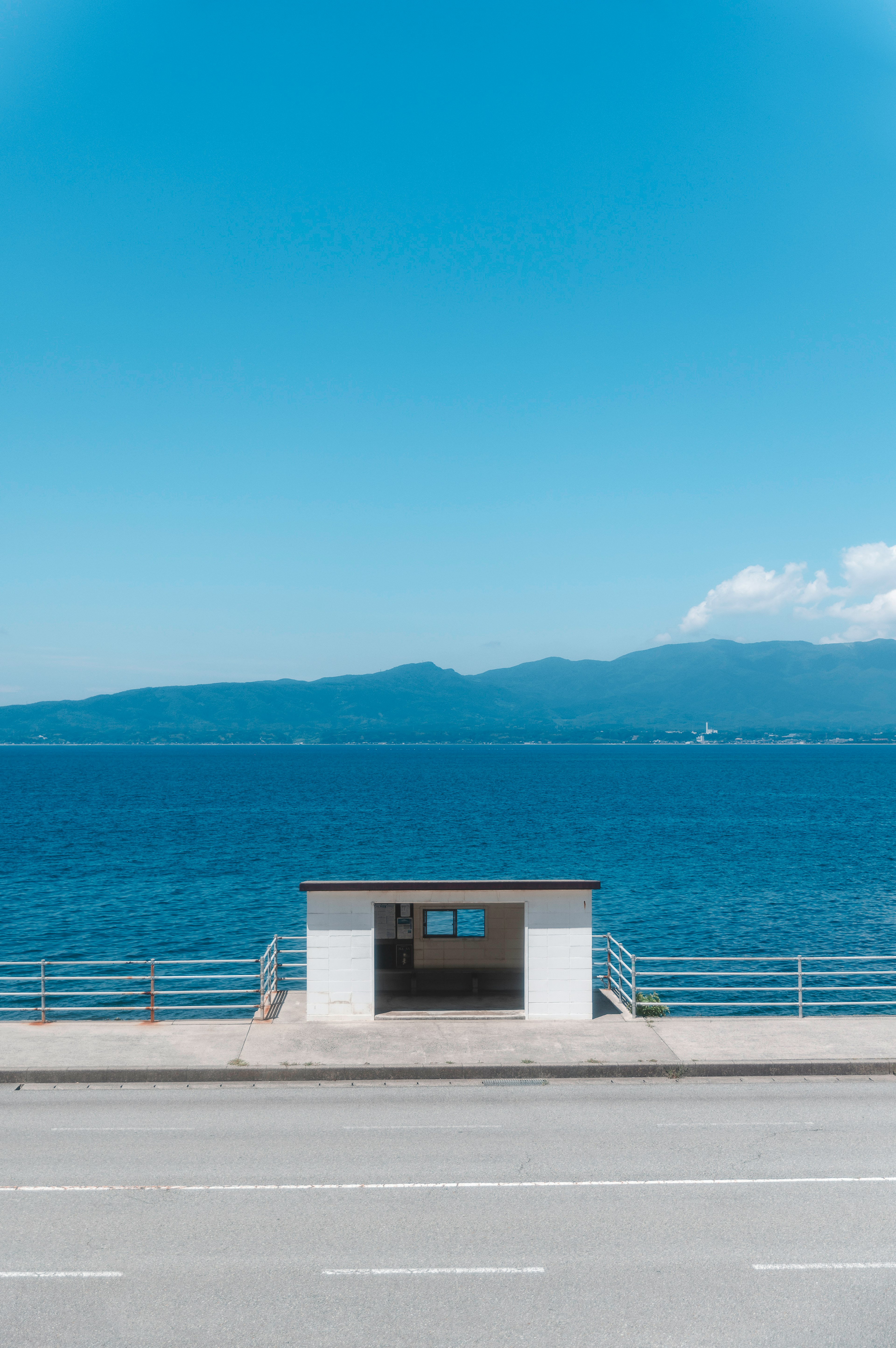 青い海と青空の下にあるバス停の風景