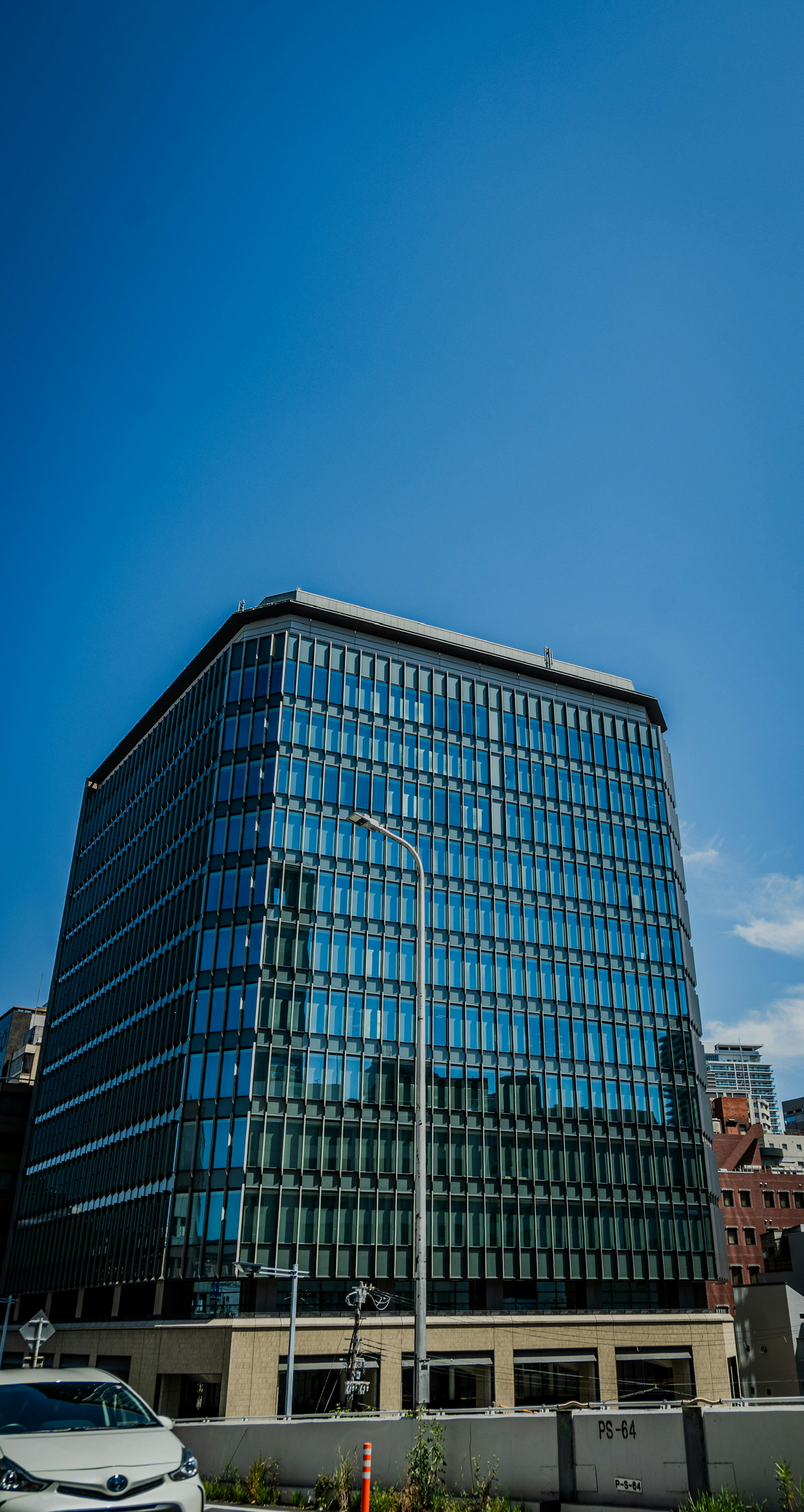 Eksterior gedung perkantoran modern di bawah langit biru yang cerah