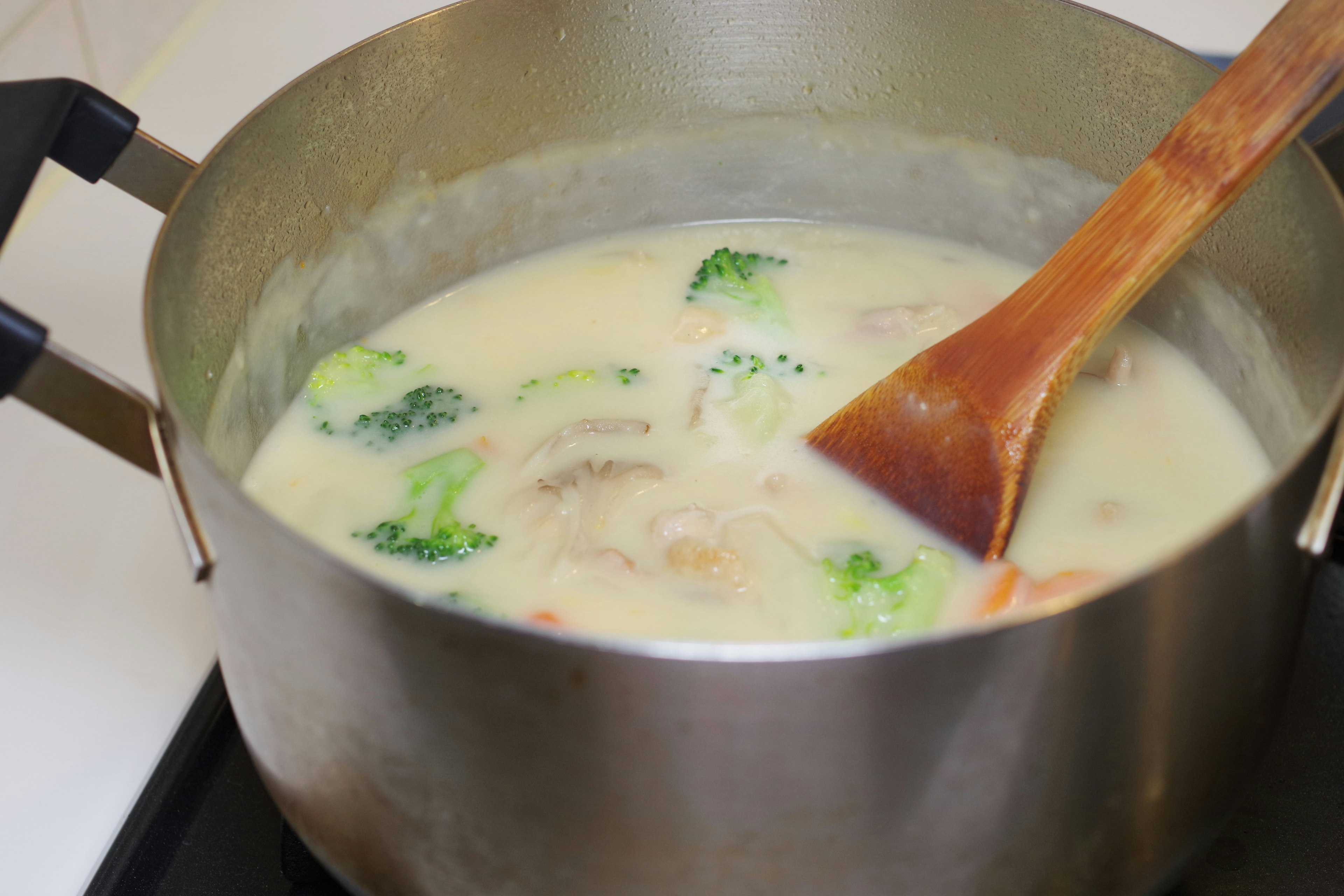 A pot filled with creamy soup and vegetables