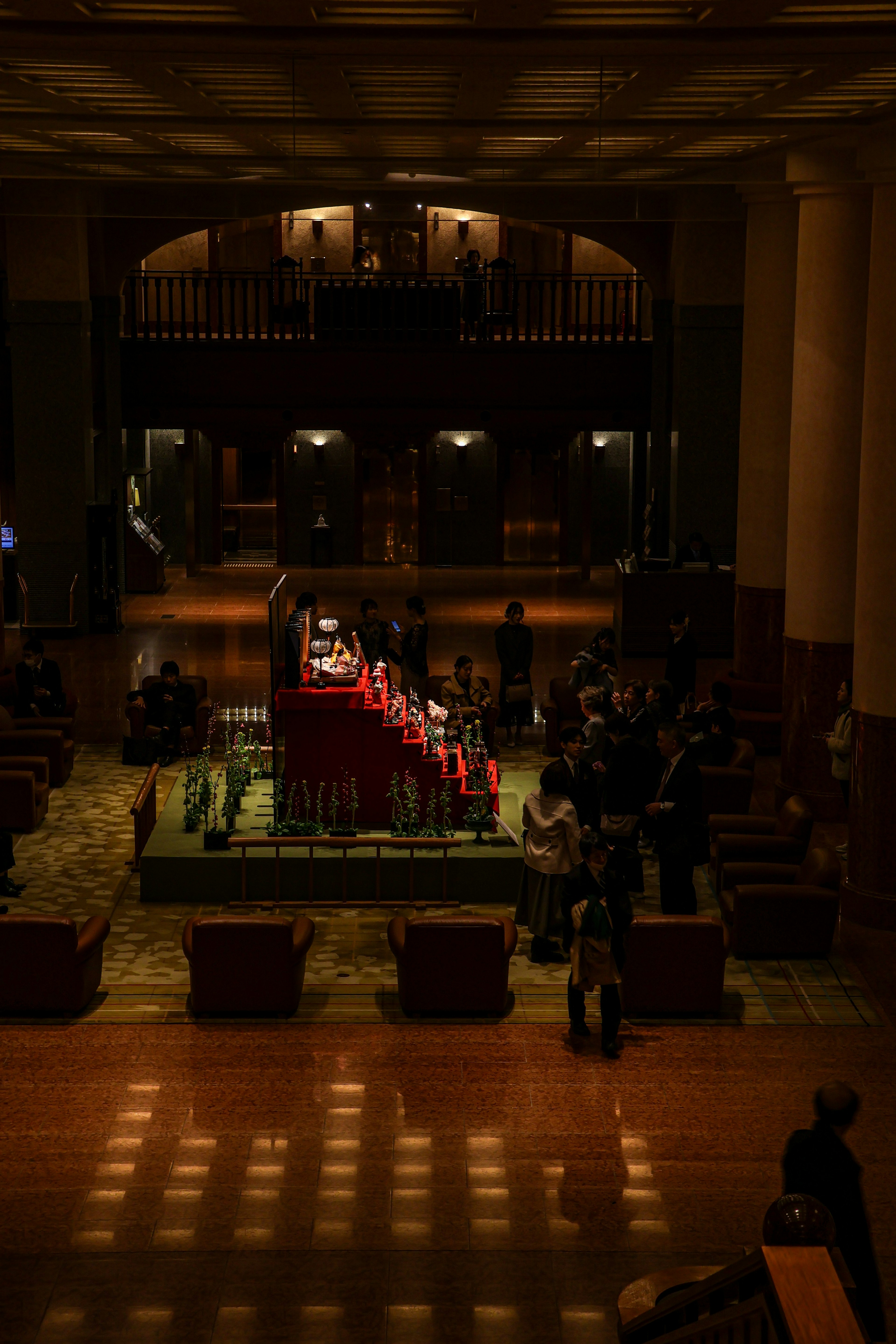 Gathering of people in red attire in a dimly lit indoor space