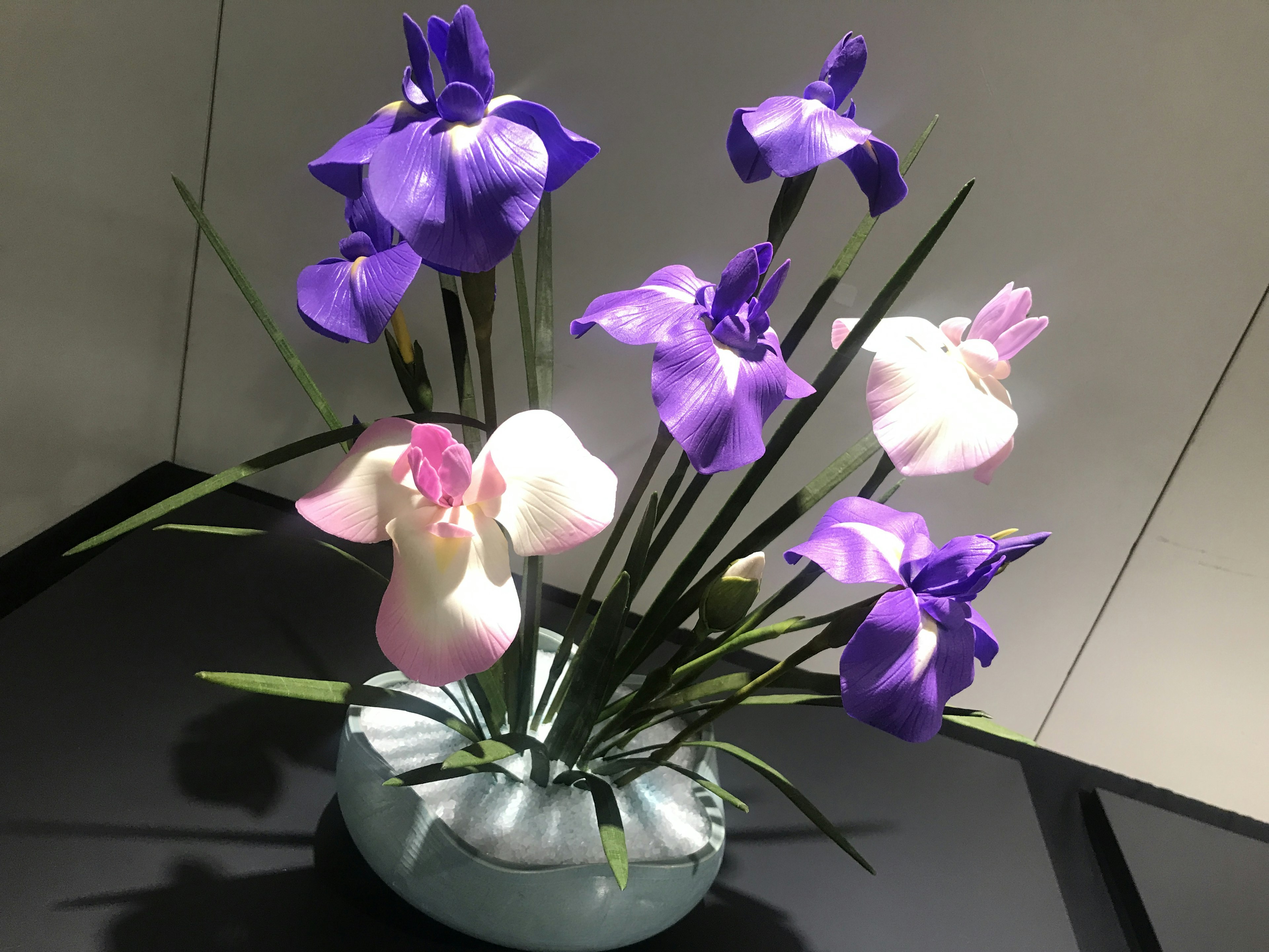 Arreglo de flores moradas y blancas en un jarrón decorativo