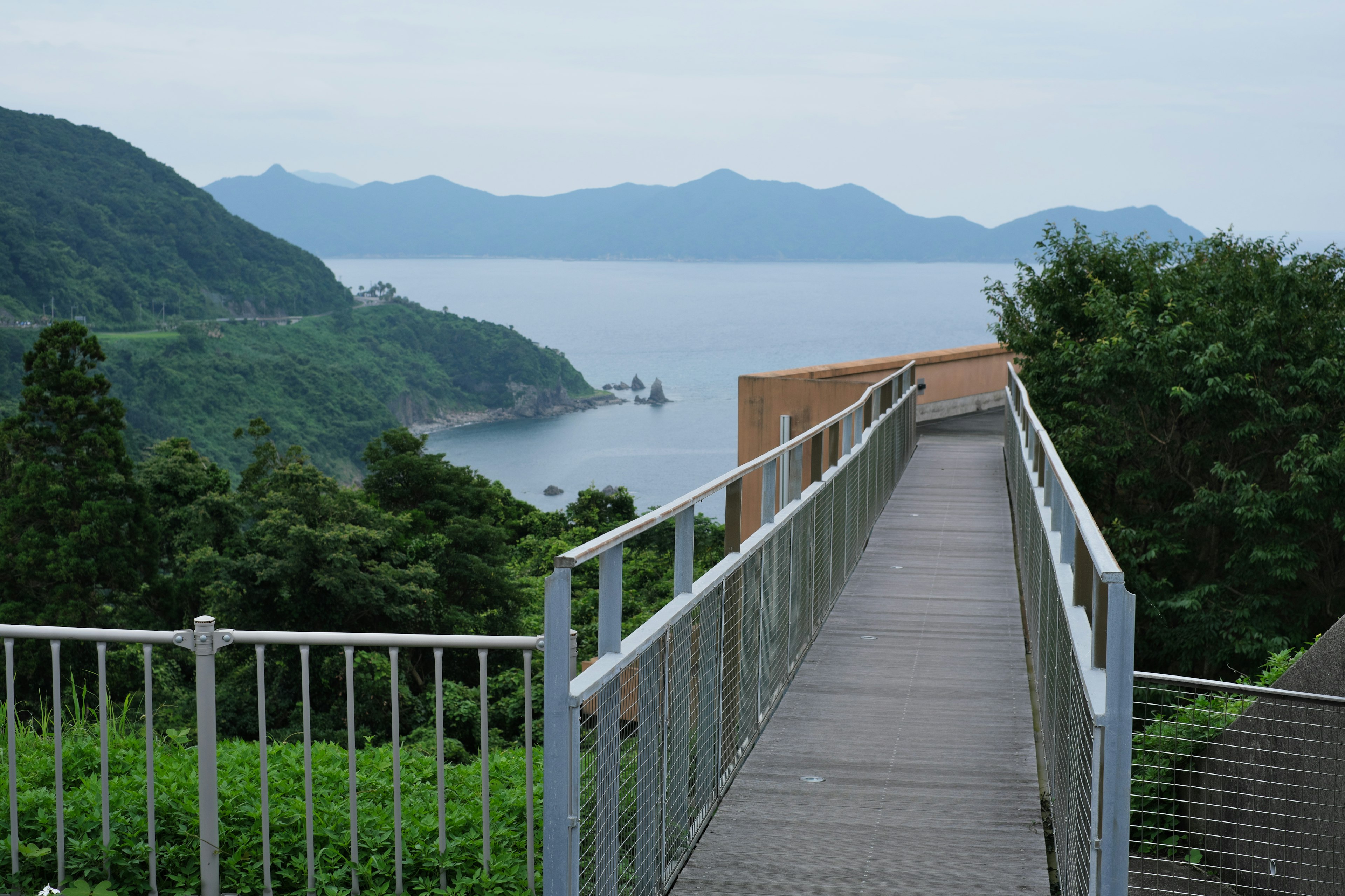 View of a walkway overlooking the sea and mountains