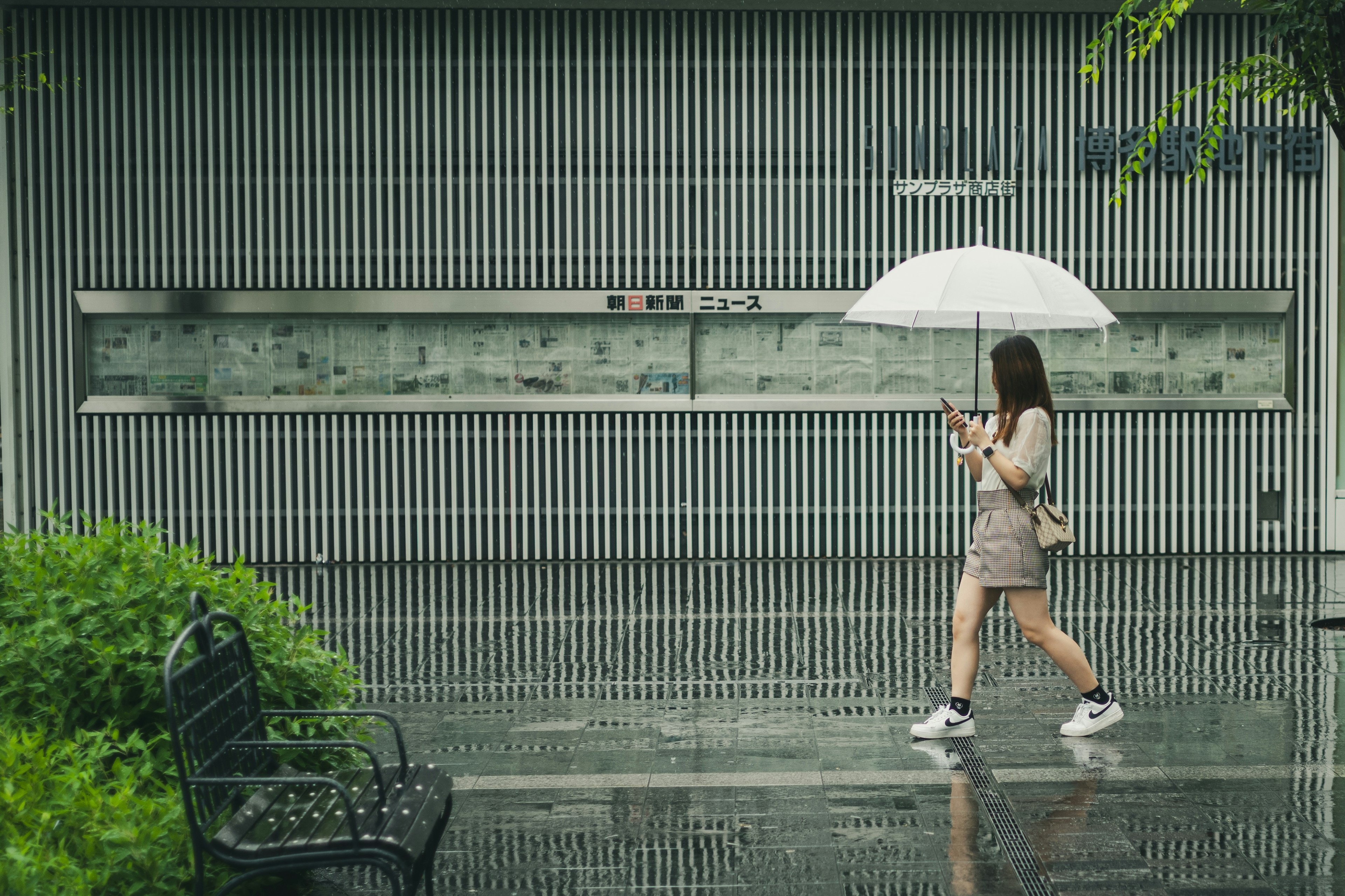 Una mujer caminando con un paraguas bajo la lluvia