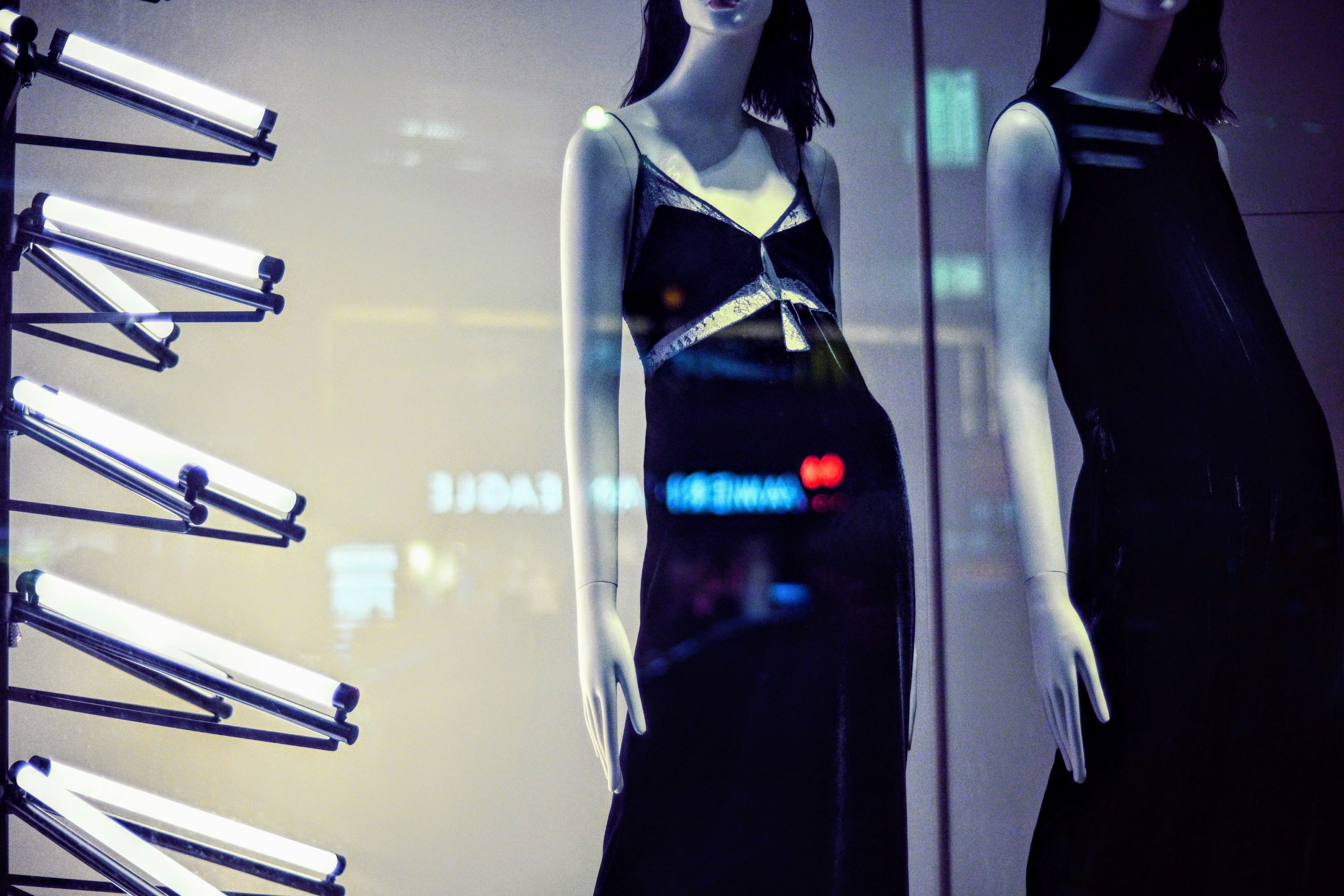 Imagen de maniquíes con vestidos negros en una vitrina elegante