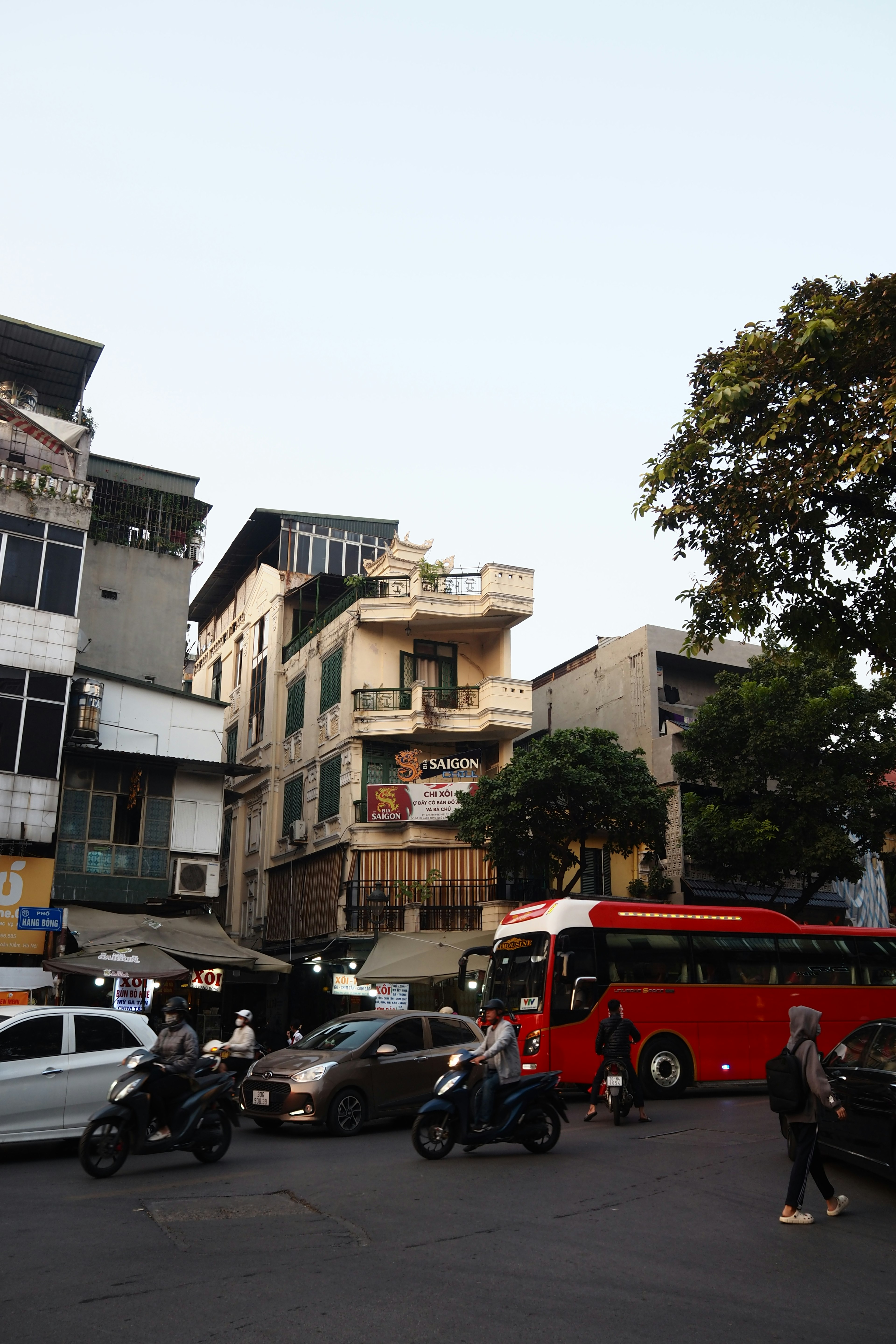 街角有一栋黄色建筑和一辆红色公交车