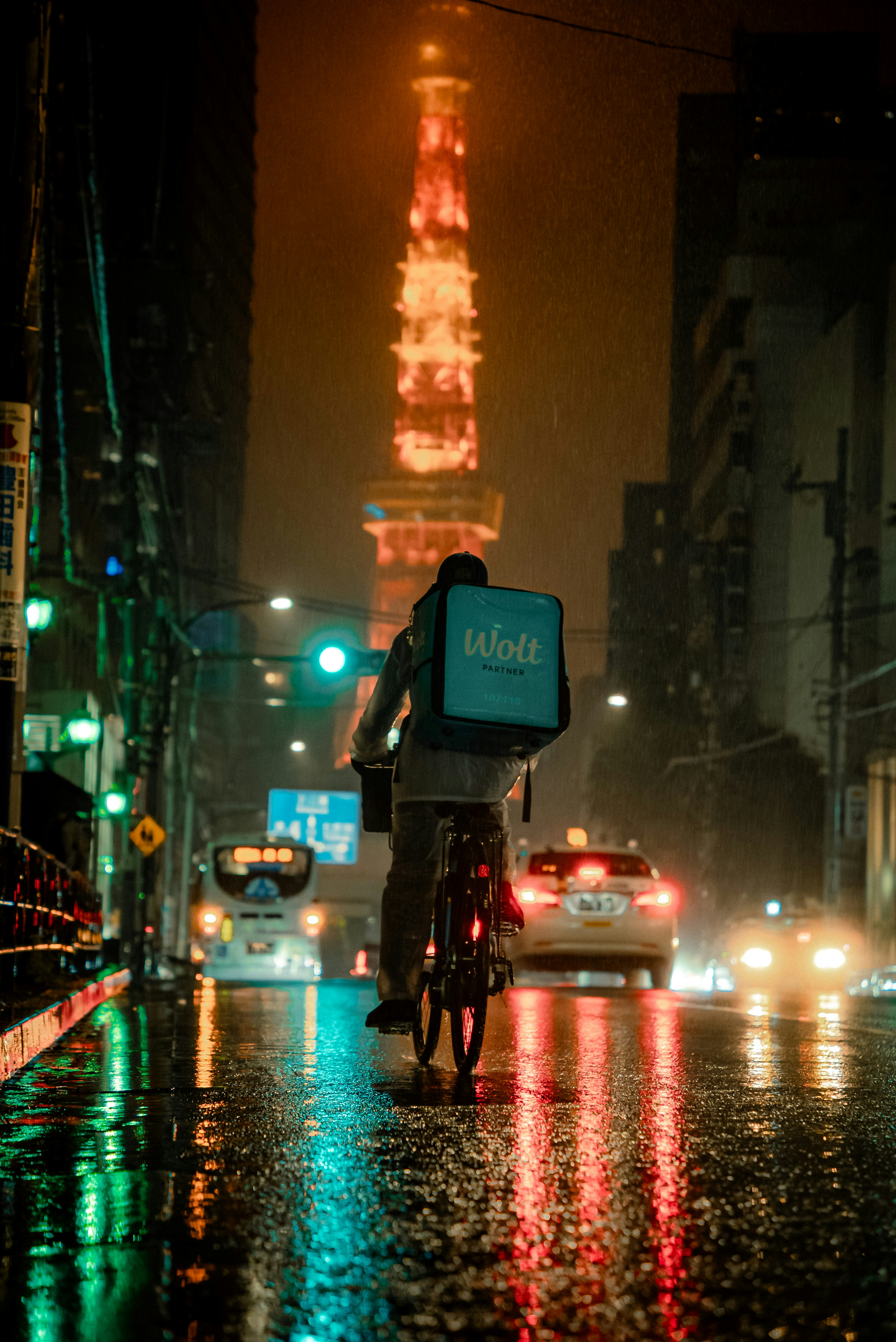 雨中騎自行車的外送員和東京塔背景