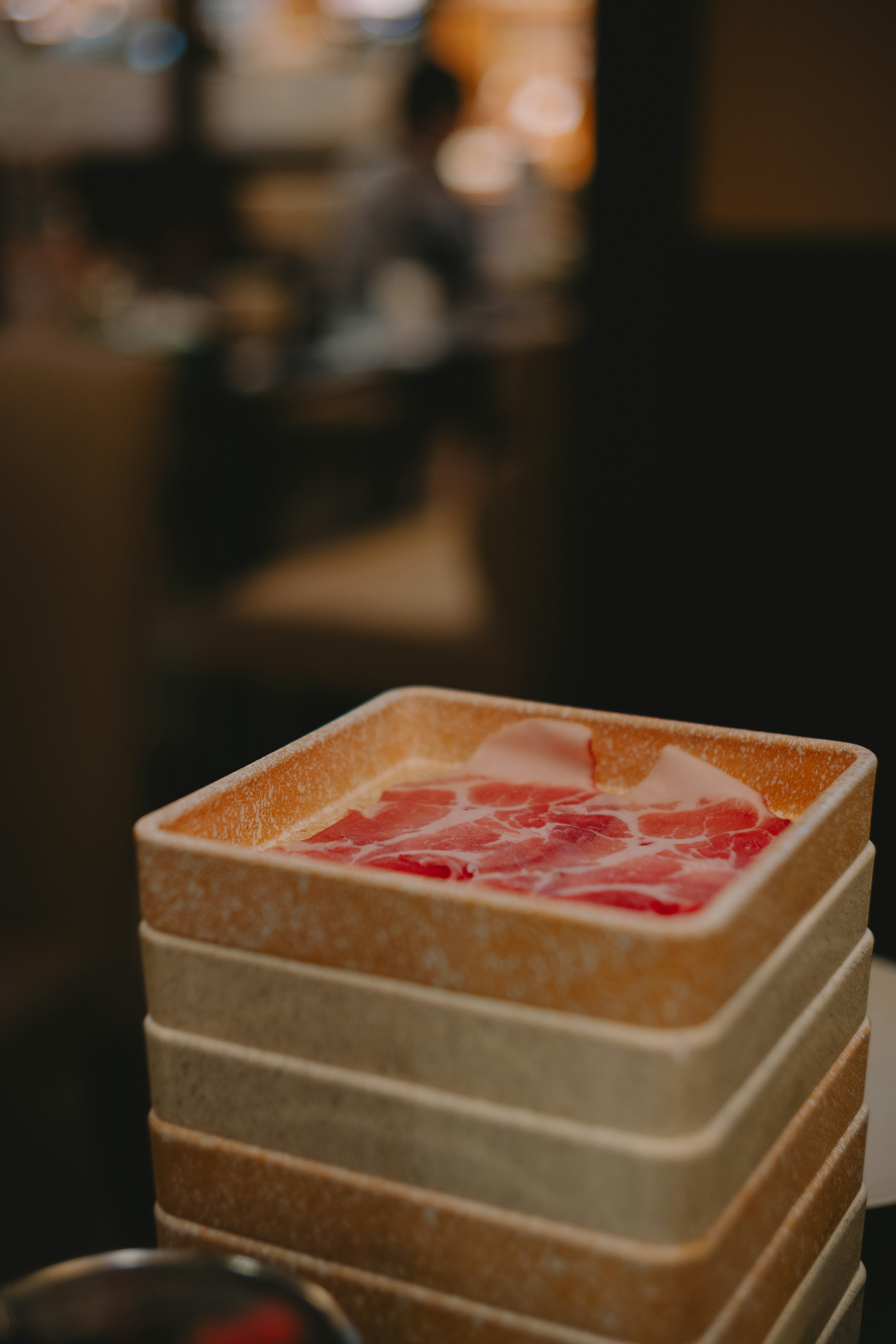 A wooden box filled with sliced meat for cooking