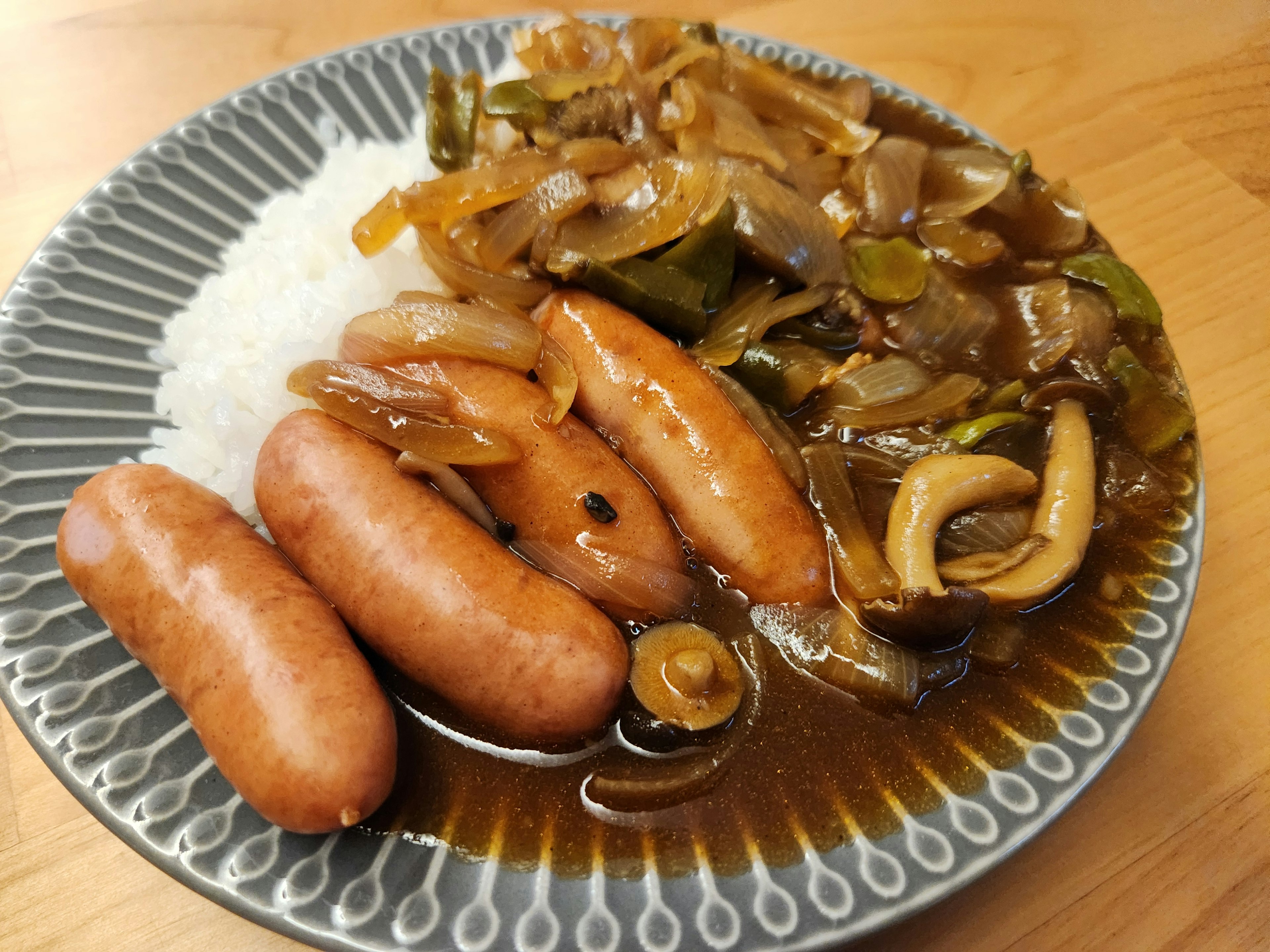 Dish featuring sausages and vegetables served over rice