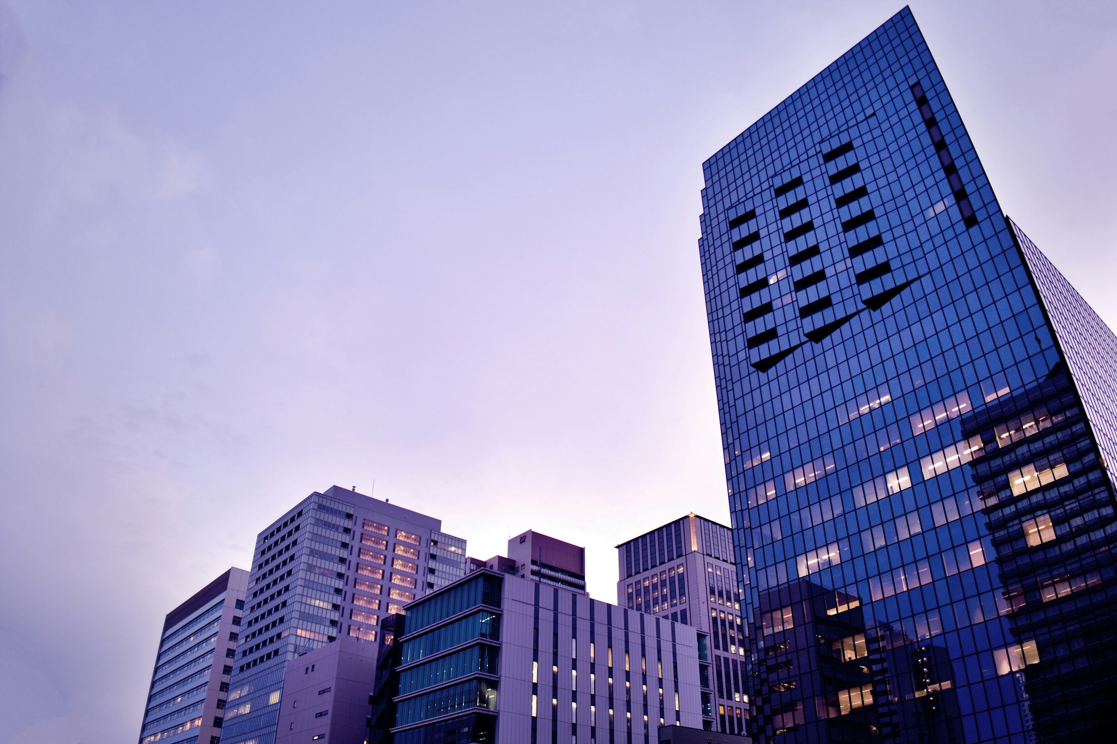 City skyline featuring tall buildings under a twilight sky with a soft color palette