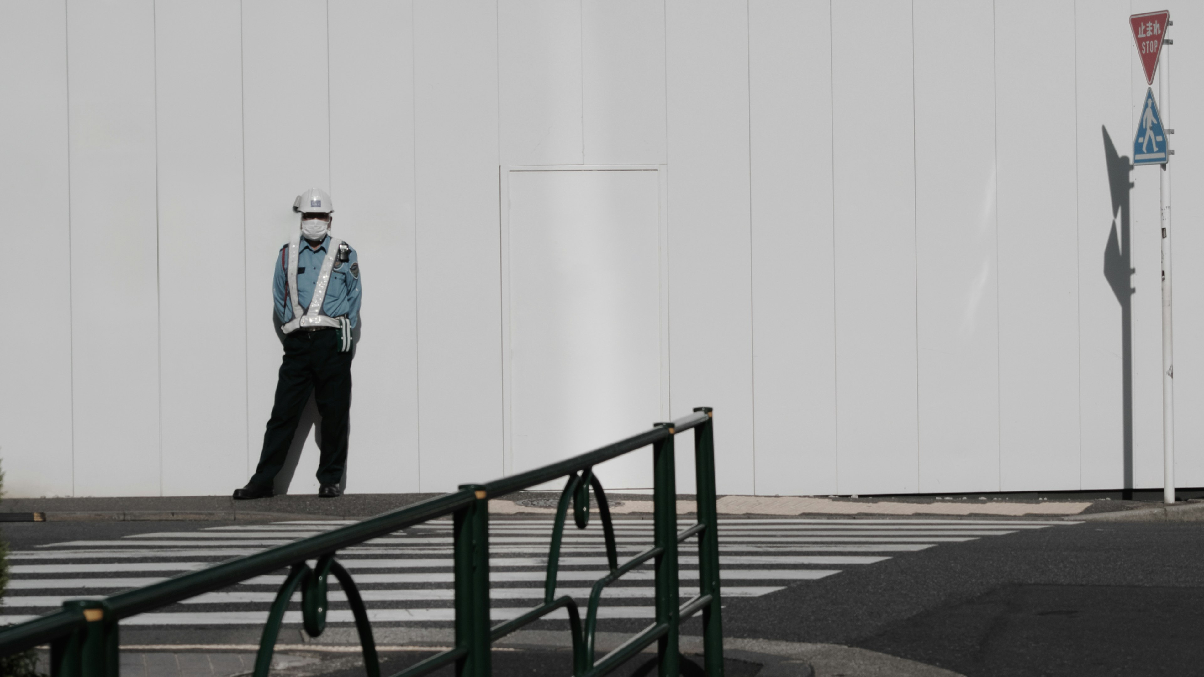 Security guard in uniform standing in front of a white wall