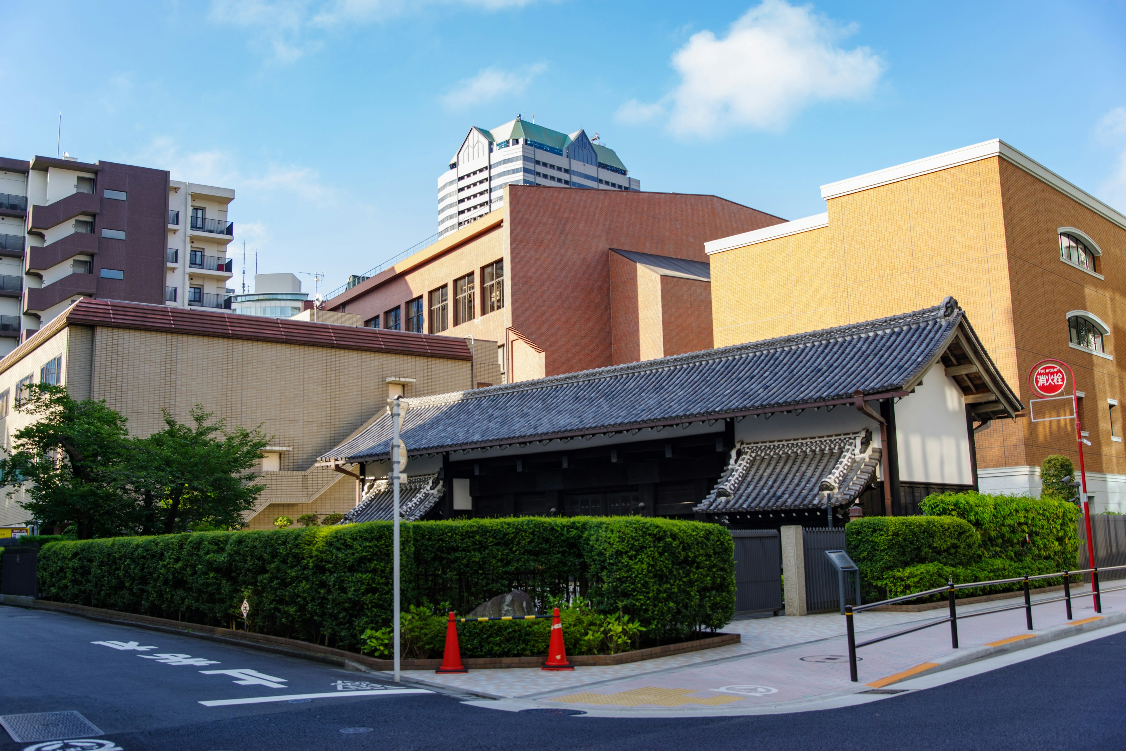 Una mezcla de edificios modernos y una casa japonesa tradicional con techo de paja