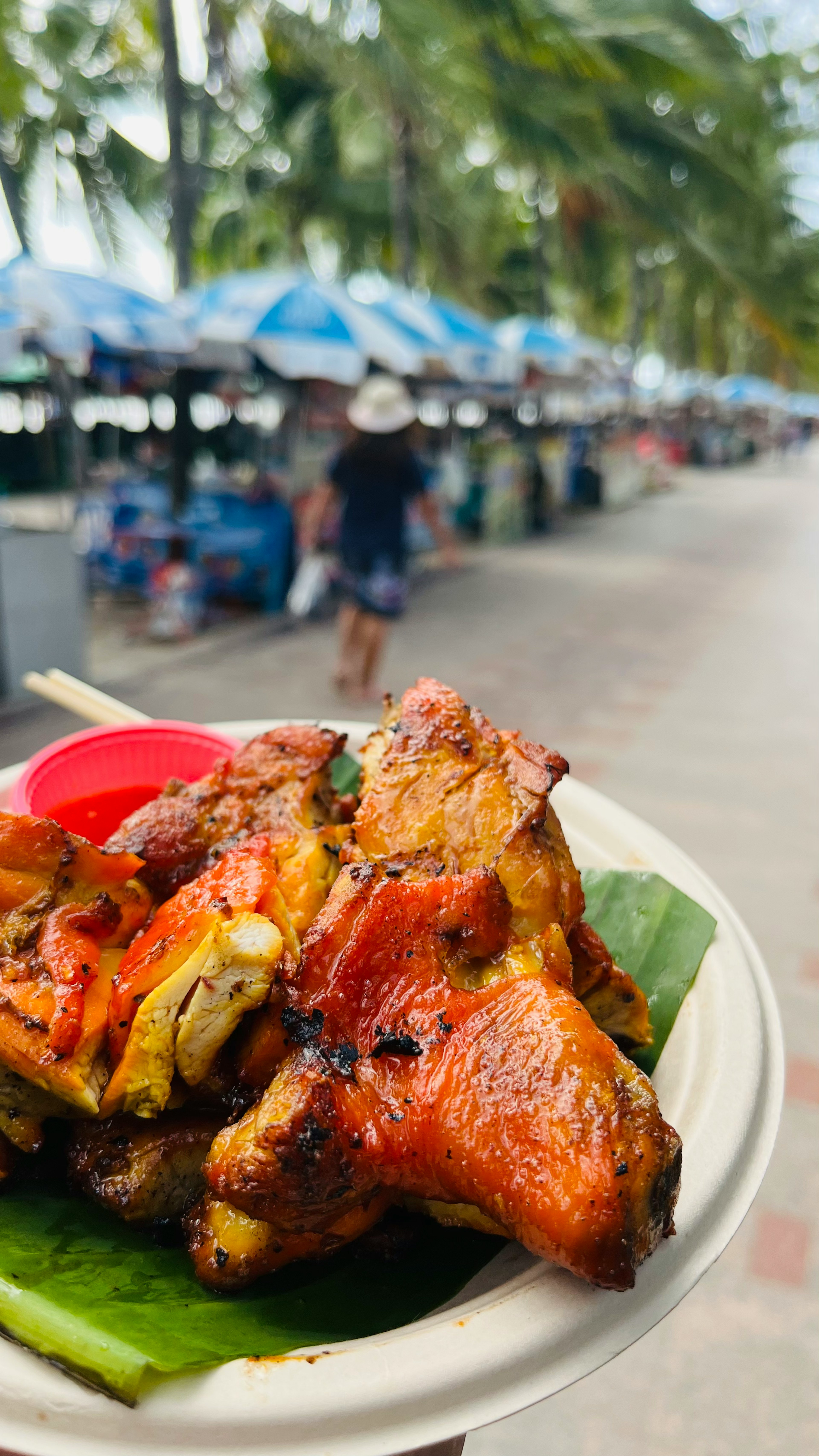 Poulet grillé dans une assiette avec des stands colorés en arrière-plan