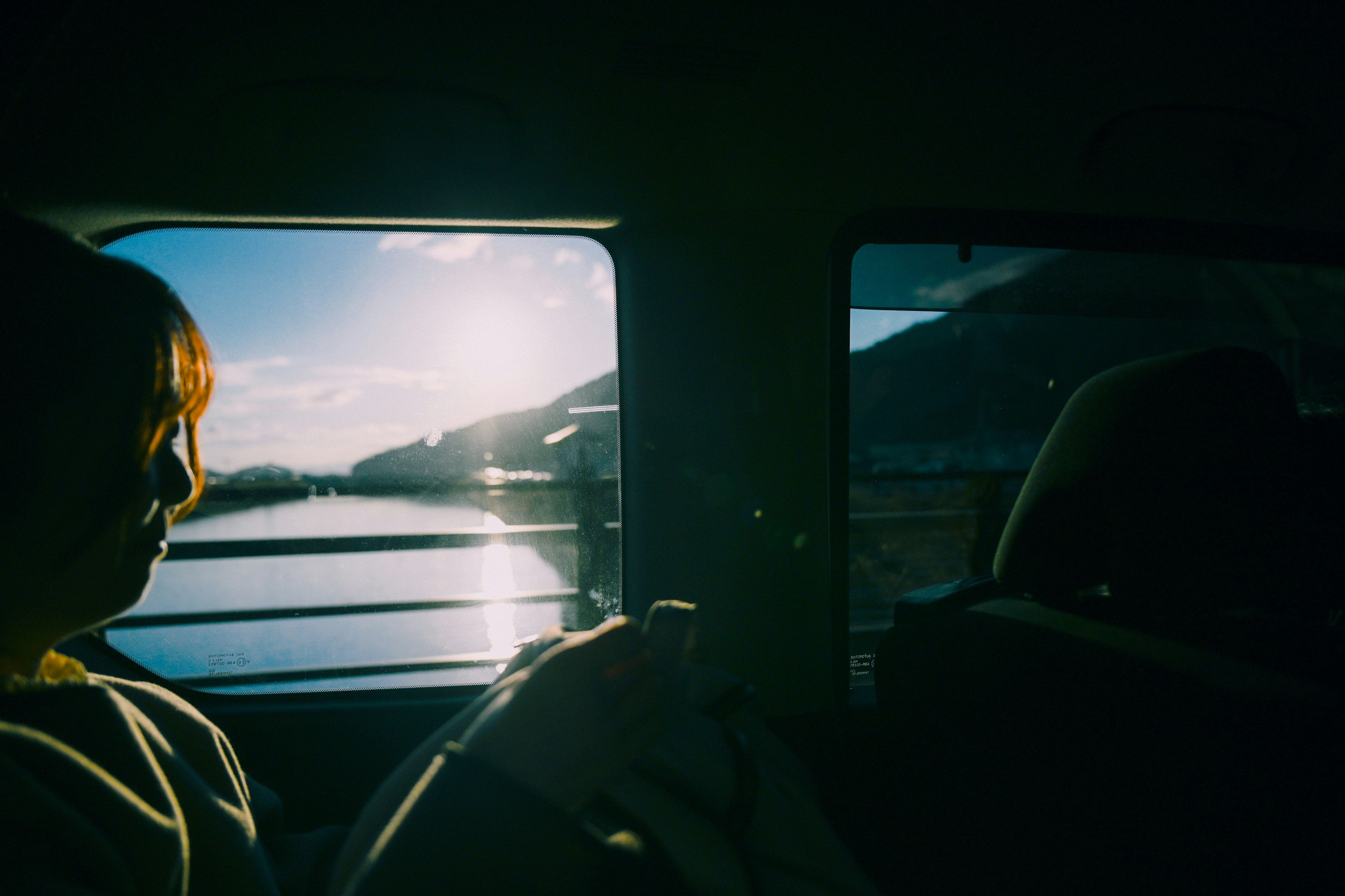 Silhouette einer Person in einem Fahrzeug mit landschaftlichem Blick nach draußen