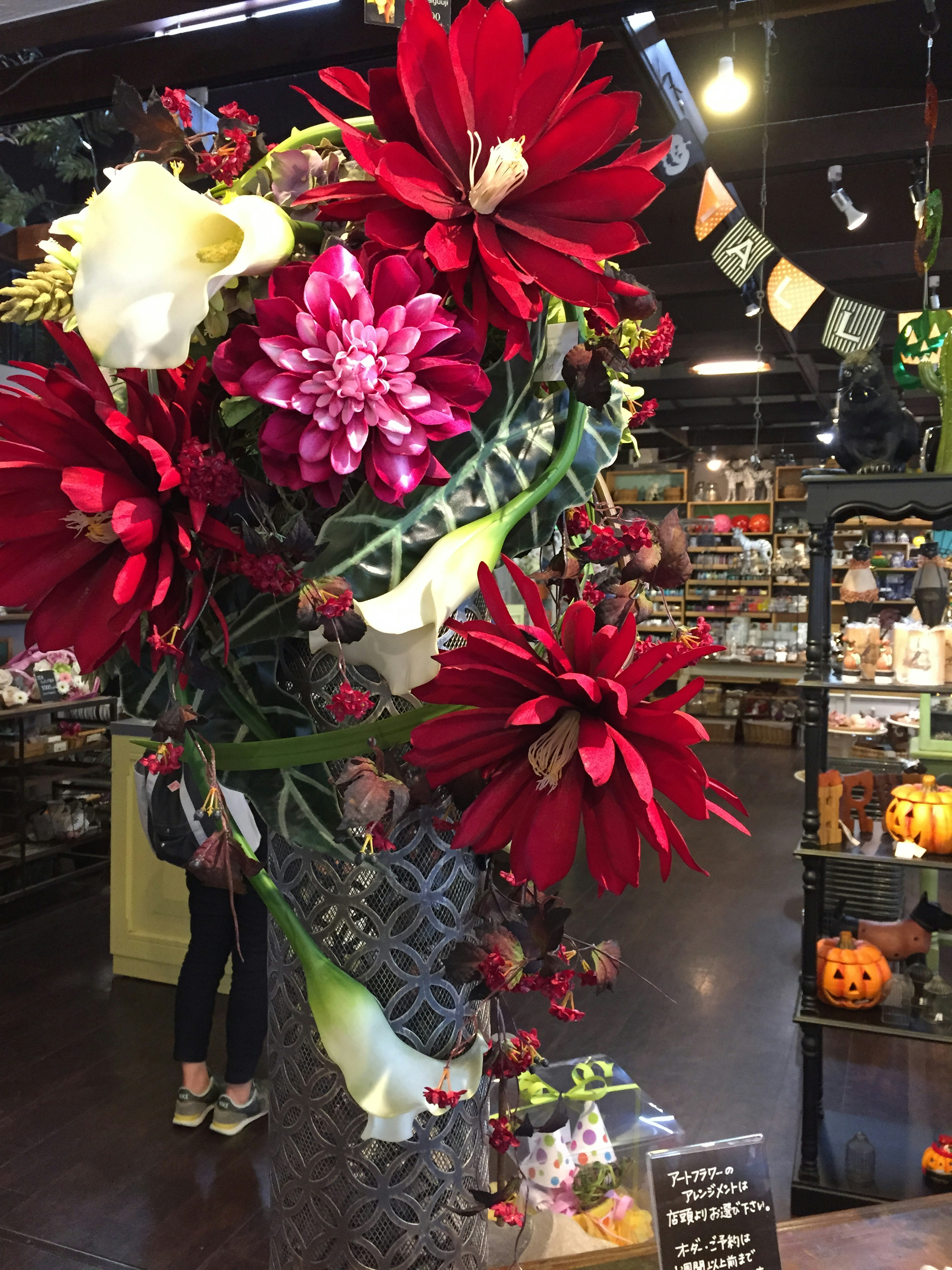 Ein lebhaftes Arrangement aus roten und weißen Blumen in einer dekorativen Vase in einem Geschäft